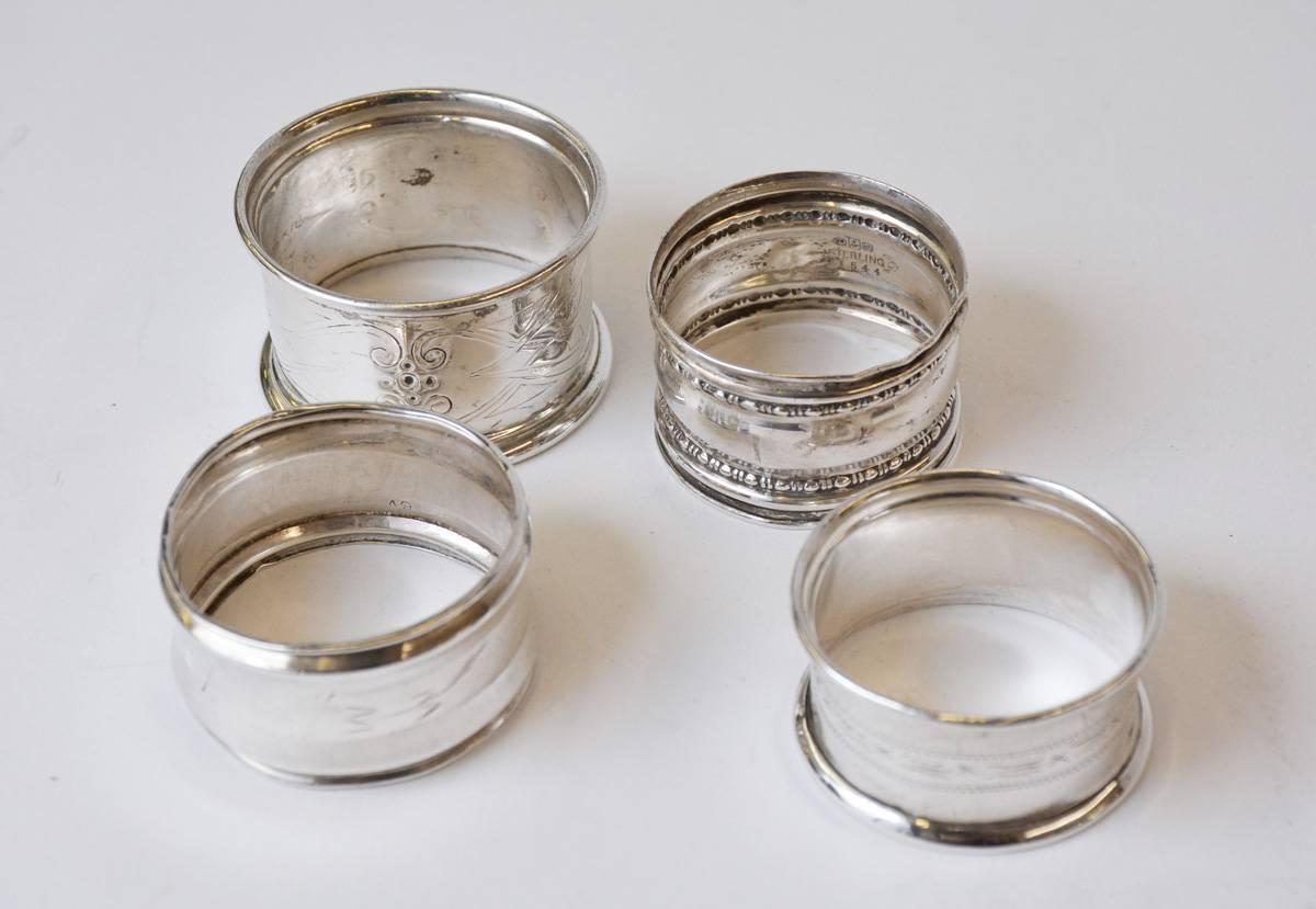 The four English antique silver napkin rings have different designs. 

(l. to r.) Greek-style scroll pattern with monograms. (see below for dimensions)
Simple leaf design. Maybe a child's napkin ring. 1.50