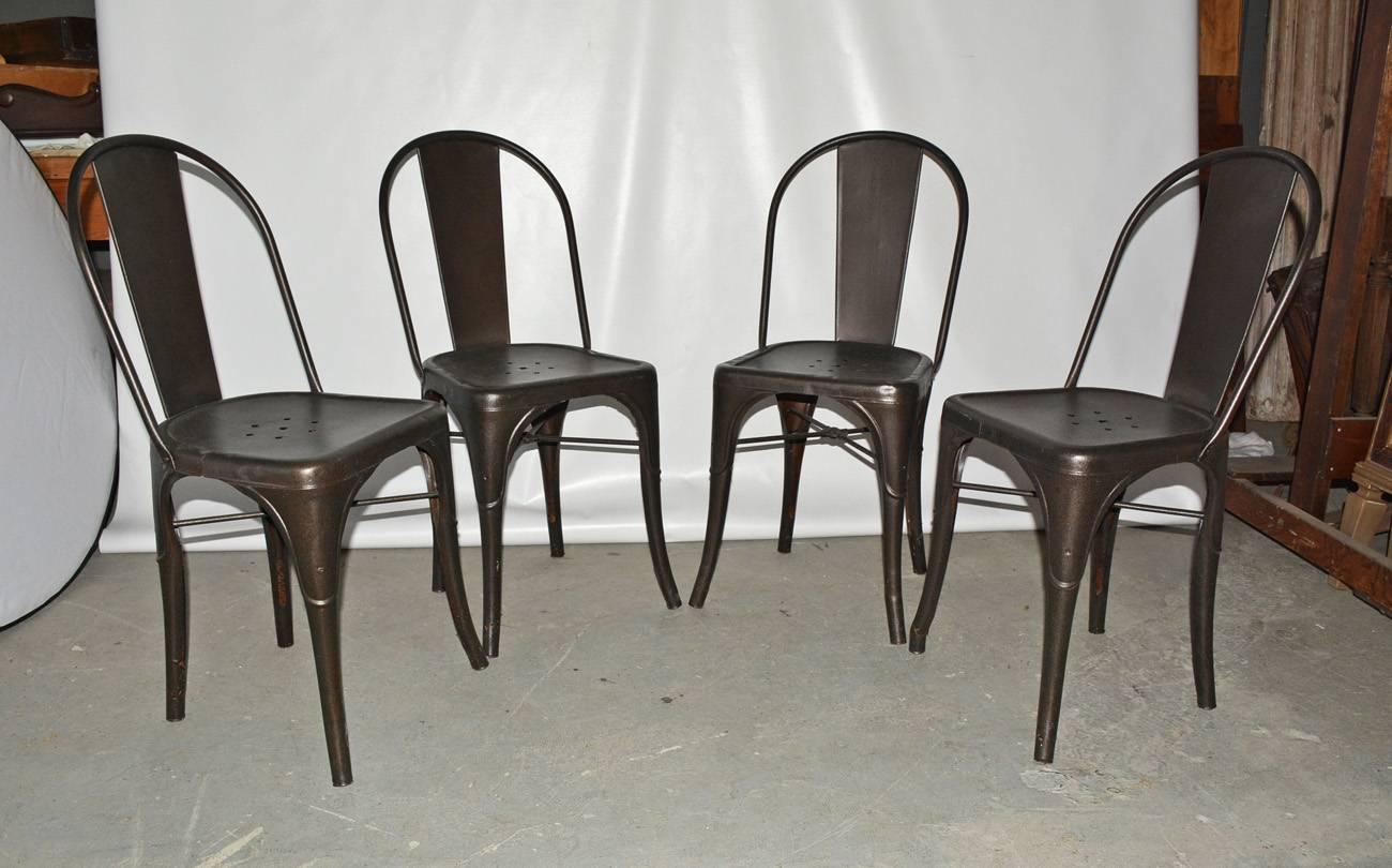 Set of four French bistrot chairs designed by Xavier Pauchard for Tolix.  The four Industrial metal dining chairs are sturdy, have small holes in the seats for water drainage which makes it perfect for indoor or outdoor use.

Search term:  garden