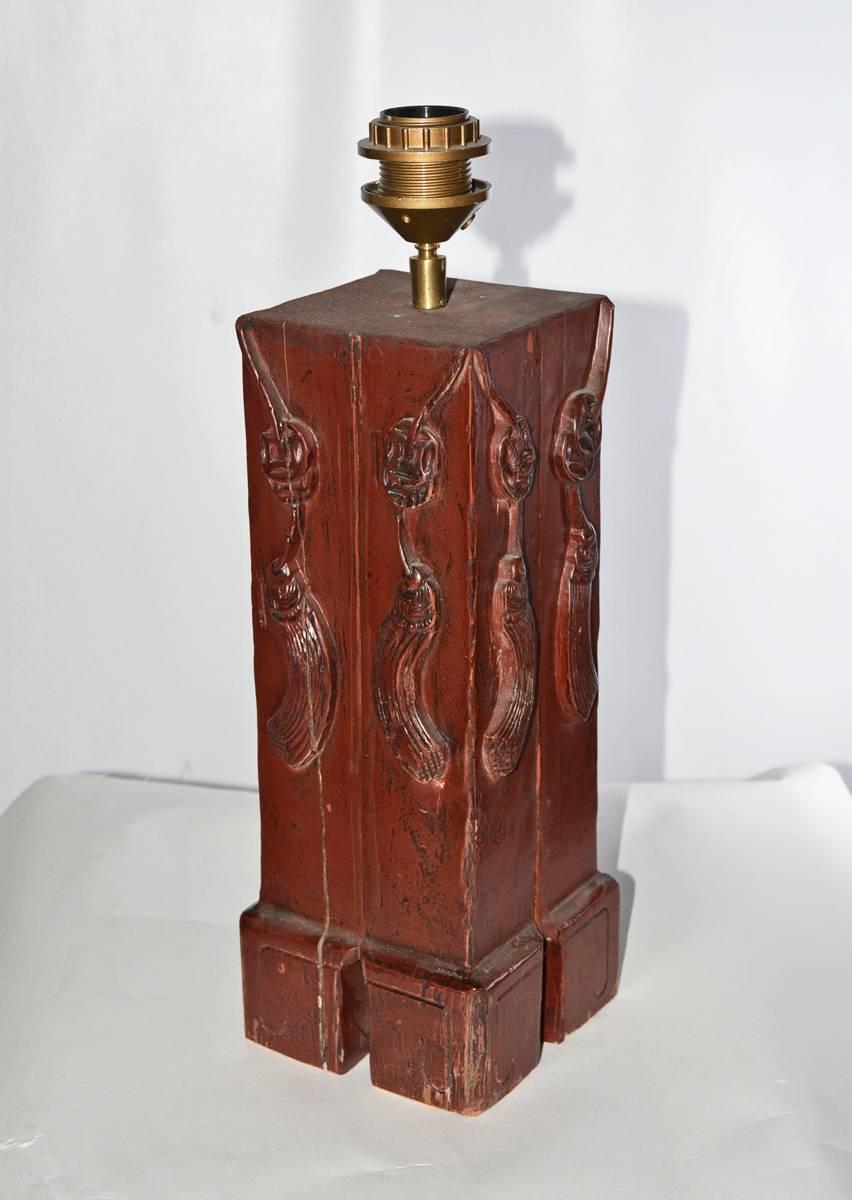 The lamp has a antique Chinese architectural wood base painted red with hand-carved tassels en relief on all four sides. The lamp is wired for US use. The socket fixture will hold shades with European-style frames. We can change socket to US style