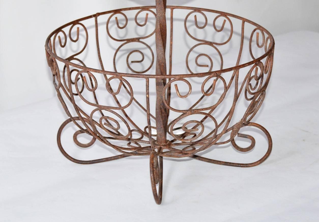 Two-tier French wrought iron basket will make a great centerpiece for the kitchen counter or sideboard. Fill it with fruit or other decorative objects to make an attractive showing.