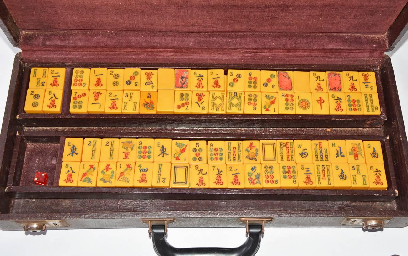 The vintage mah jong set has a leatherette carrying case that contains five long holders for the 152 tiles divided between two trays. There is also one red die.