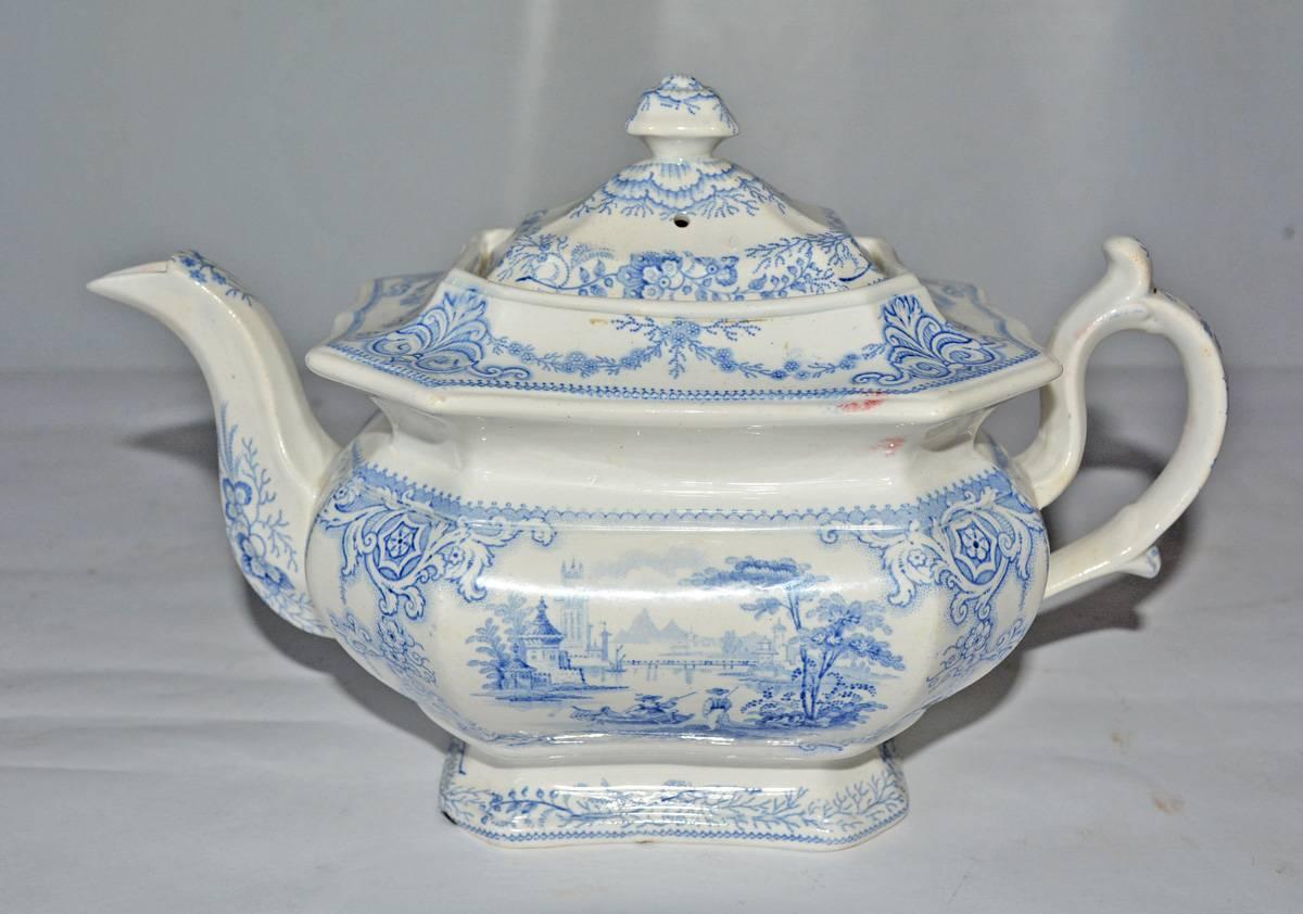 The 19th century Victorian English tea set with gracious proportions, composed of tea pot, sugar and creamer dates from the 1840s due to its pale blue coloring and decoration. The pieces are made of soft paste pottery. Labels on the bottom read