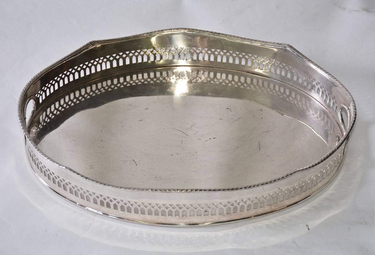 The vintage silver plate gallery serving tray has a reticulated border and two handles. Great for tea or drinks. Label on the bottom reads 
