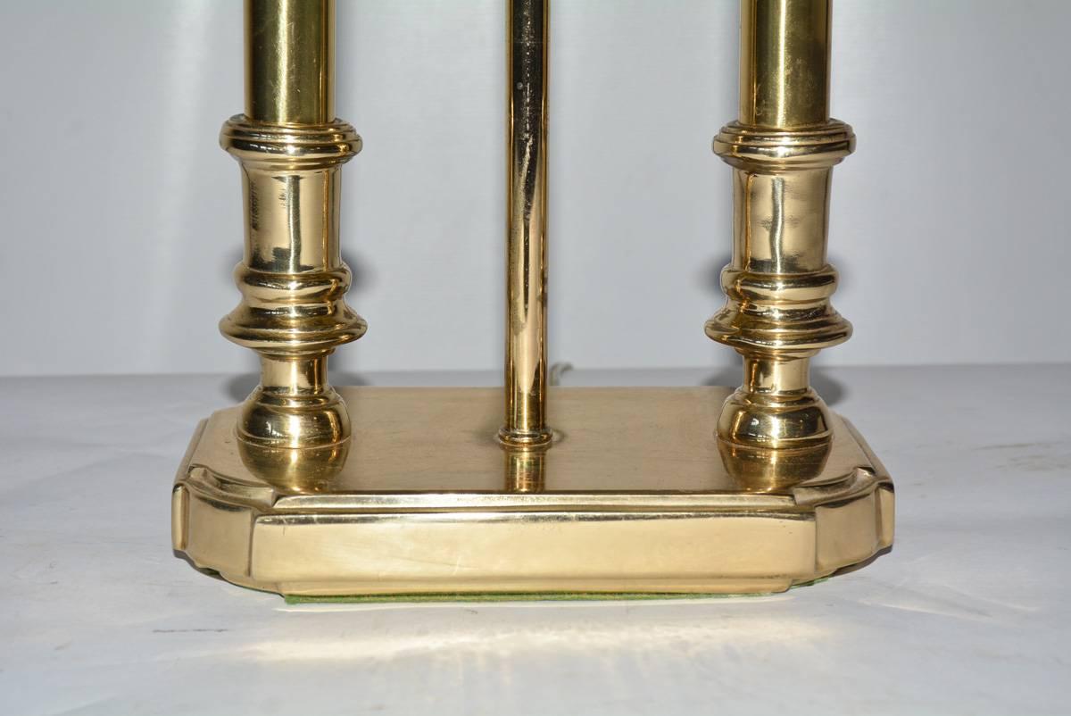 Brass bouillotte style desk lamp, though it looks to have two lights, there is only a single centre one wired for US use. The shade is black on the outside and gold inside.

Measure: lampshade top: Depth 5.5