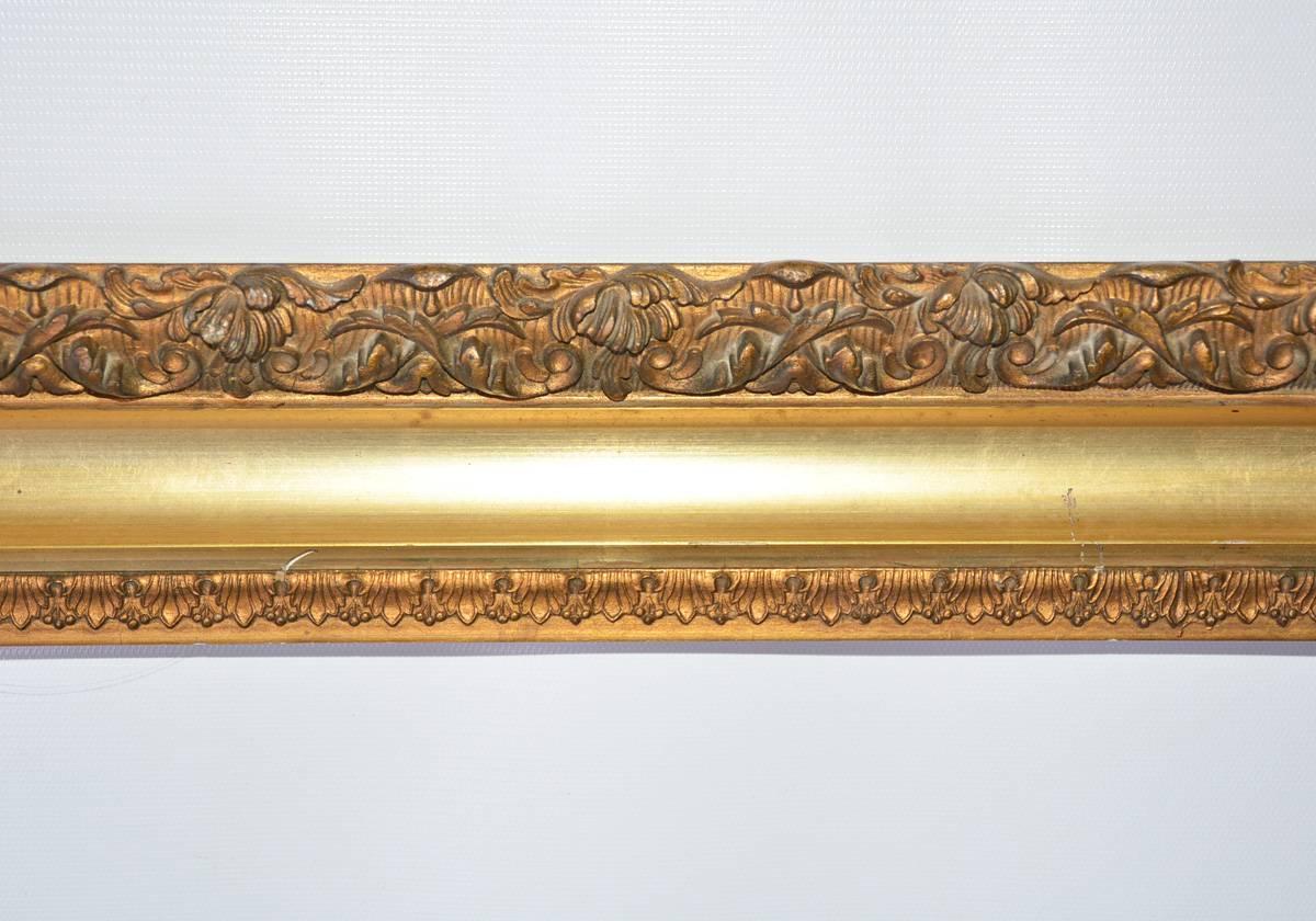 The antique gilt-on-wood frame has a molded floral border on the outer edge, shiney gold in the middle and another design on the inner edge.

Inside of frame - D 18.13, H 24