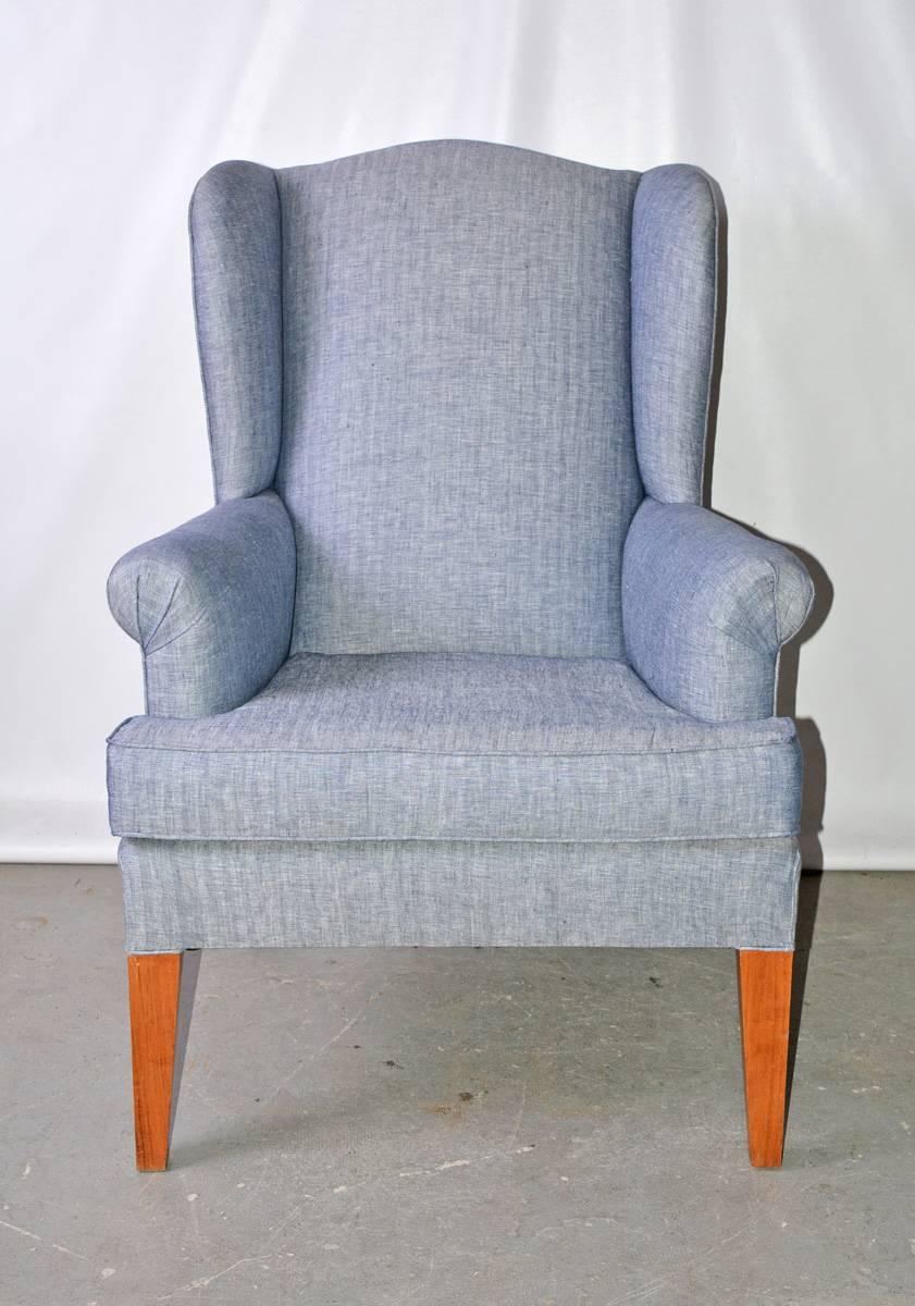The vintage wing back armchairhas been newly upholstered in blue herringbone cotton. The legs are made of tapered blond wood.

Arm height: 25.50