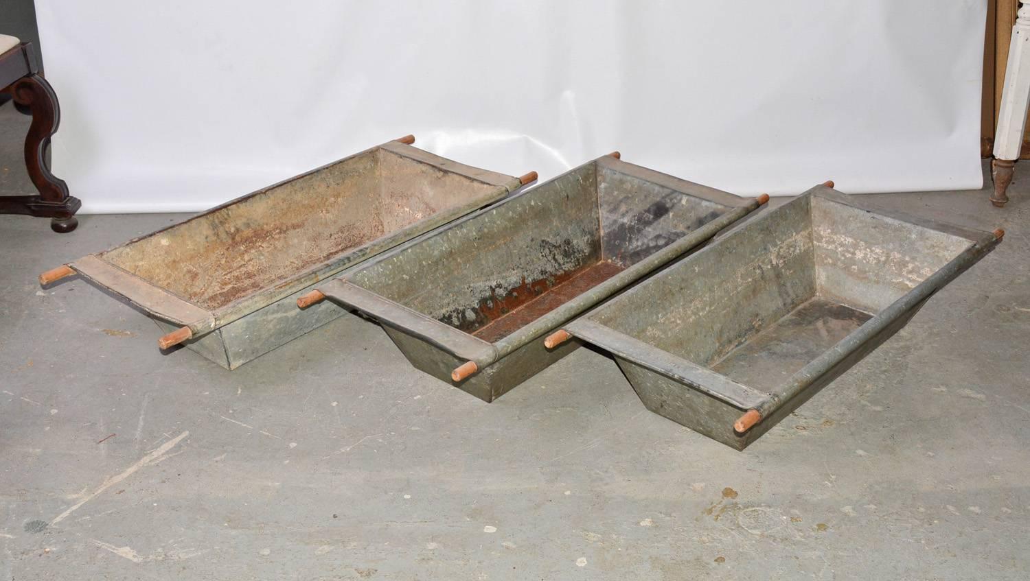 The three large troughs are made of galvanized iron and each has four wood handles.
Wonderful to hold wood, or fall bounty for display or planter. Perfect as a centerpiece on harvest table. These are sold individually.
Two have a shorter width of