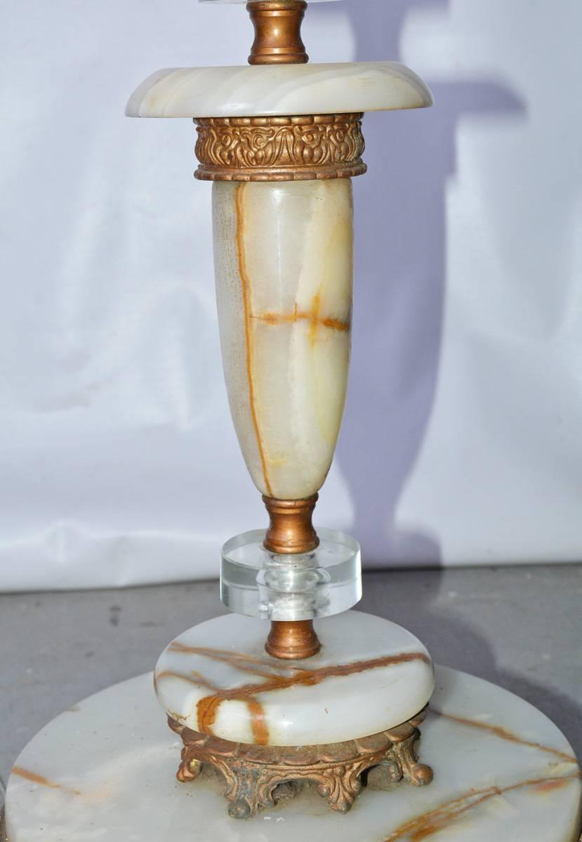 Mélange de modernité, de classicisme et d'Art déco, ce lampadaire est composé d'une base en marbre veiné et d'une tige sectionnelle en lucite composée d'anneaux et de tubes torsadés. Le fond est en métal doré. La lampe est électrifiée pour une