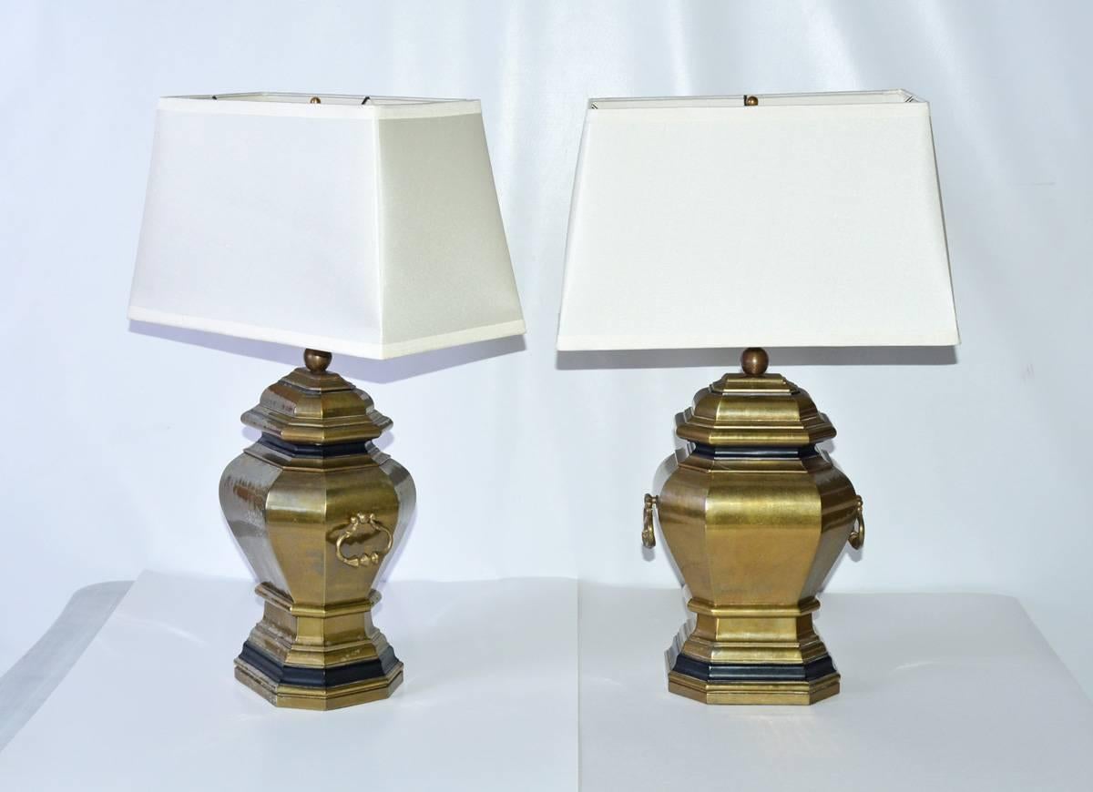 The pair of vintage brass lamps is stylized urns with handles. The bases are trimmed in black and the bottoms are lined with felt. The rectangular shades are made of cream-colored plastic. The lamps are electrified for US use.
Measures:
Lampshade