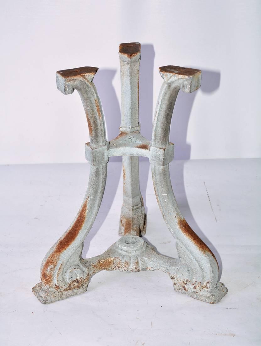 The small Victorian garden table made of cast iron base is painted a grey white. The three legs end at the bottom with volutes. The antique white marble top has grey veins and was once a floor tile. The size makes a perfect side table. Great to use