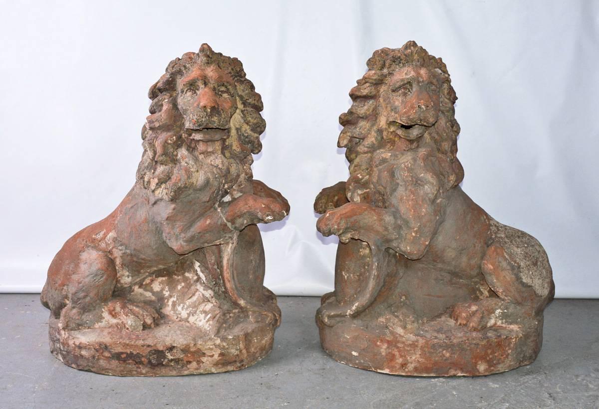 Impressive pair of 19th century Baroque style terracotta lions, with animated expressions, fully-maned heads turned in opposing directions.
