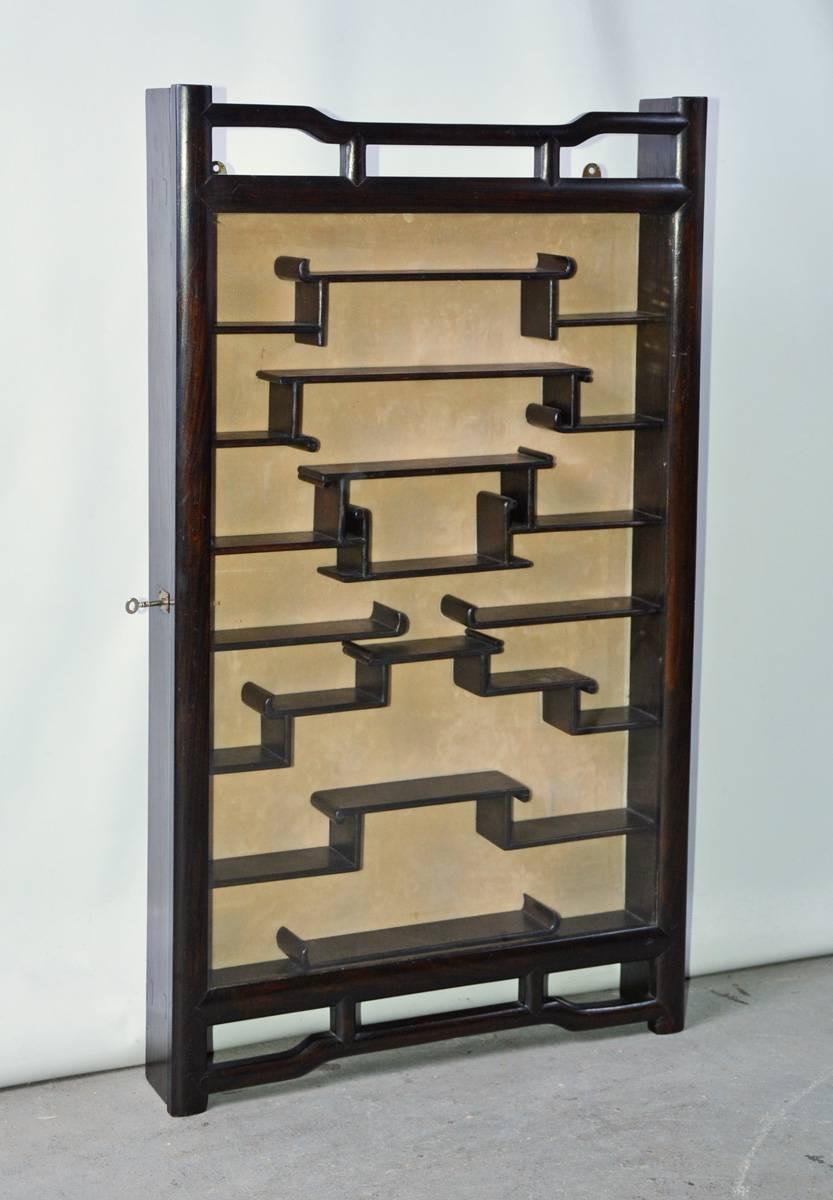 This exquisite piece features six shelves with varying levels and glass door for displaying small items such as jade carvings and snuff bottles. The case can be freestanding or wall hung. 

Depth inside display: 2.13