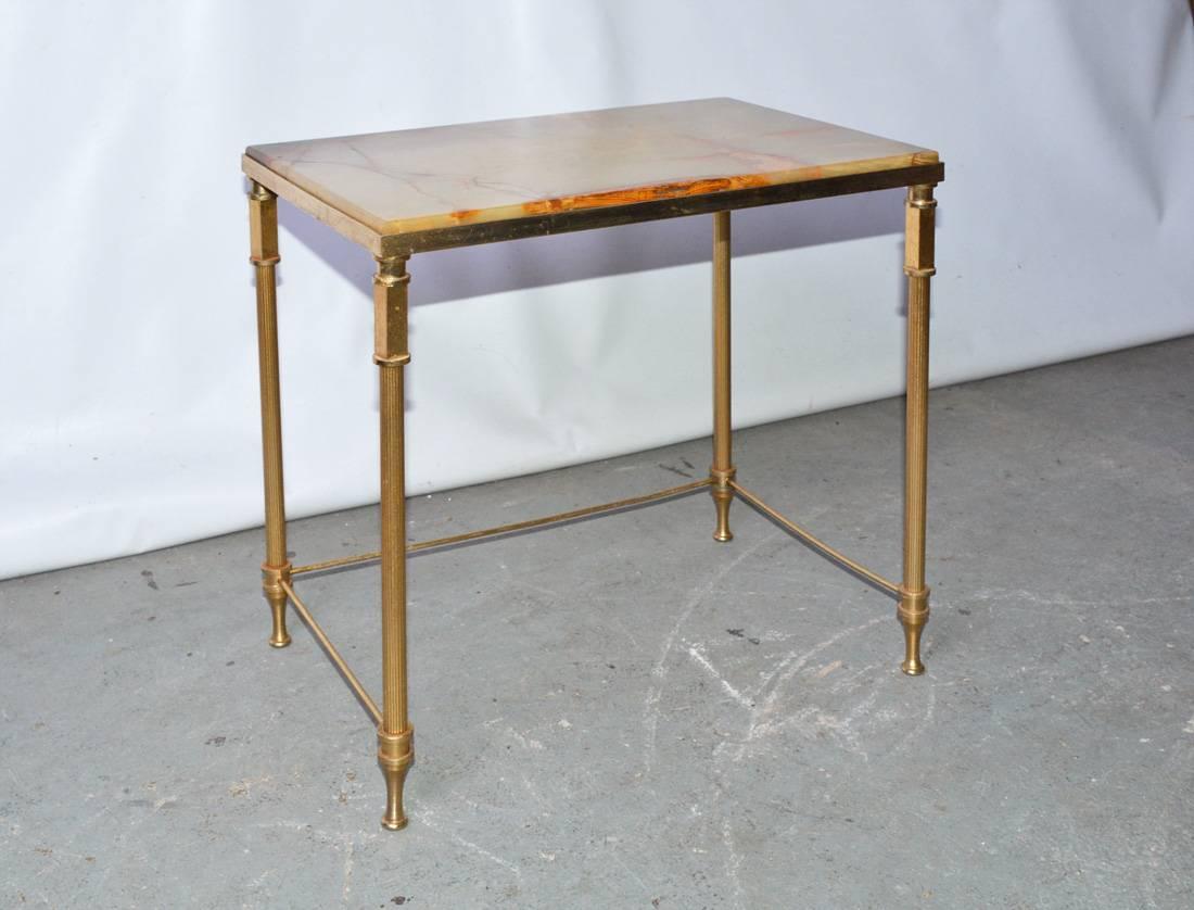 An elegant Hollywood Regency bronze side or occasional table with onyx inset and brass frame. Once a trio of stacking table.