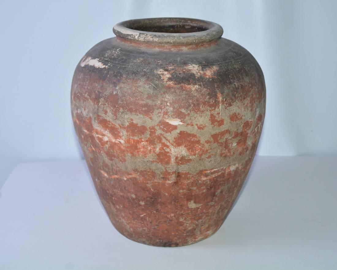 A very fine quality late 19th century medium size terracotta urn or jar with gorgeous original patina. This terracotta storage jar or jardiniere features a lip leading to gracefully shaped rounded belly. The planter is nicely weathered in a red