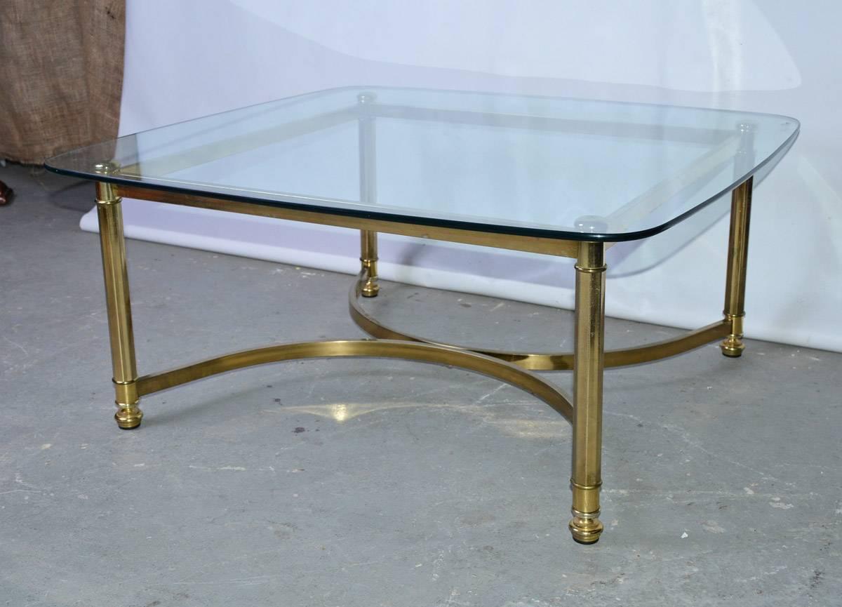 Neoclassical style Italian coffee table with brass base and glass top.

Some scratches on glass and faded gilt paint on base.