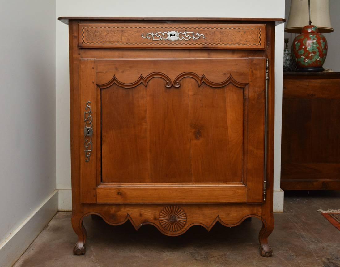 Superbe exemple d'un meuble provincial Louis XV du XVIIIe siècle ou antérieur - en merisier - incrustation en forme d'œil d'oiseau sur le tiroir. La quincaillerie d'origine, les serrures de tiroir et de porte fonctionnent avec la même clé.