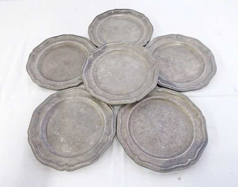 The six vintage scalloped pewter dinner plates are in the American Colonial style. Stamped 