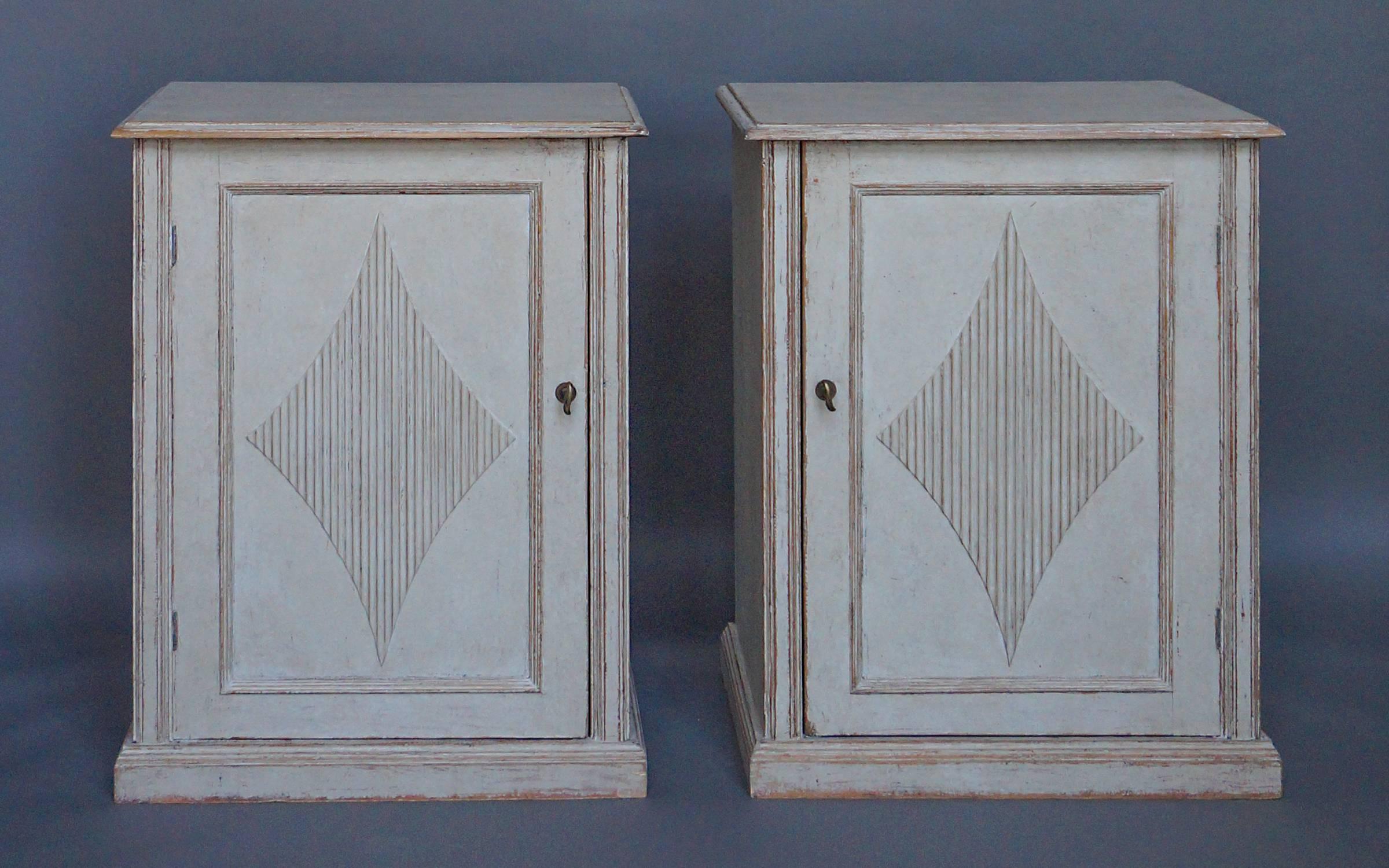 Pair of Swedish cabinets, circa 1880 in the Gustavian style. Paneled doors with reeded lozenges and a single interior shelf in each.