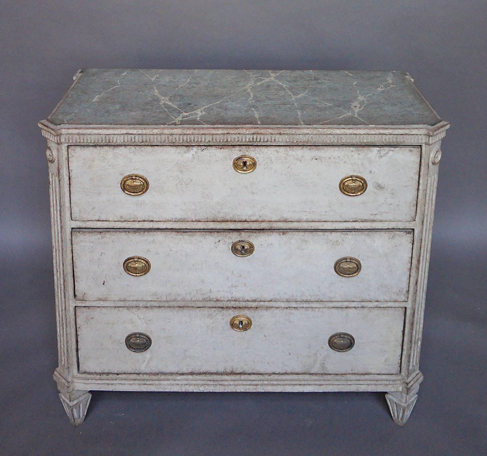 Three-drawer chest from the neoclassical period, Sweden, circa 1850. The top drawer features a raised lattice pattern and sits above a band of projecting molding. Dentil molding on the front and sides below the marbled top and bold reeding at the