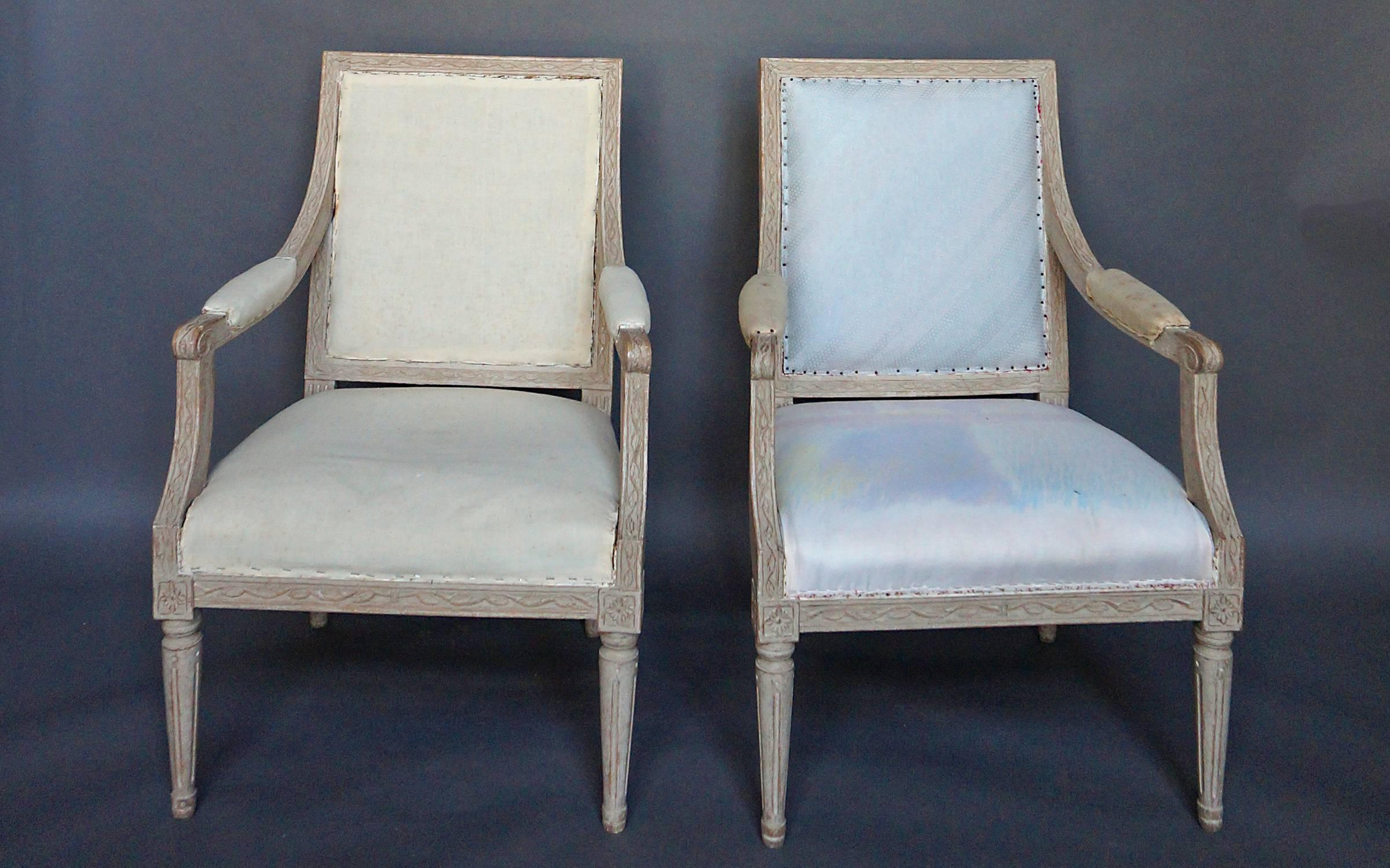 Pair of armchairs in the Gustavian style, Sweden, 1910. Exposed frame with graceful leaf and vine carving throughout. Upholstered seat, back and armrests.
