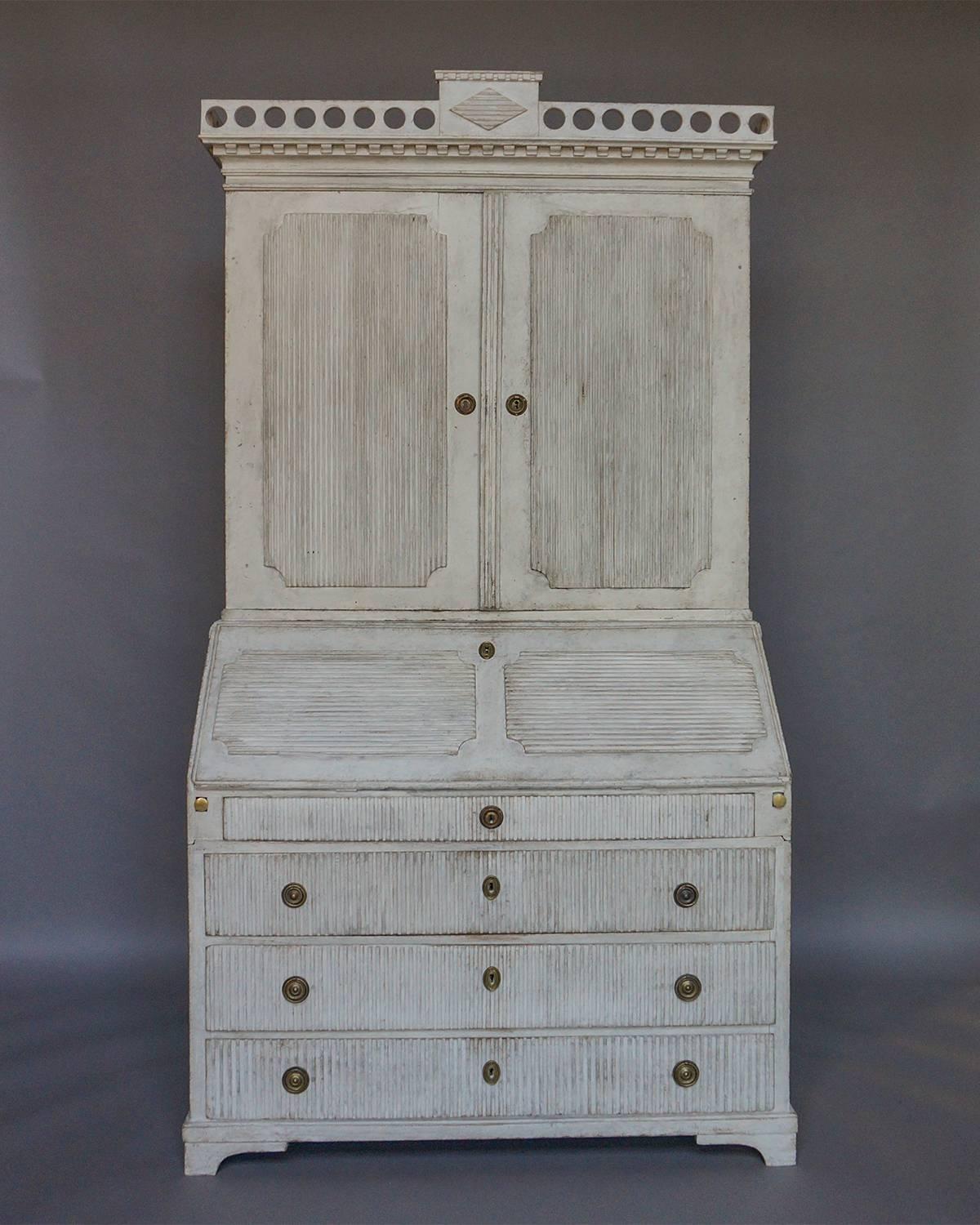 Period Gustavian secretary in two parts, Sweden, circa 1770. The upper section has double doors with raised, reeded panels opening onto three shelves and a locking compartment. At the top is a pierced cornice with central reeded lozenge.

The