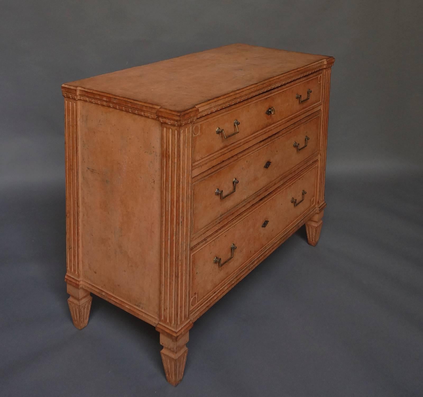 Swedish neoclassical chest of drawers, circa 1850, in salmon paint. Dentil molding, reeded corner columns, and raised panels on the drawer fronts. Brass pulls and escutcheons.