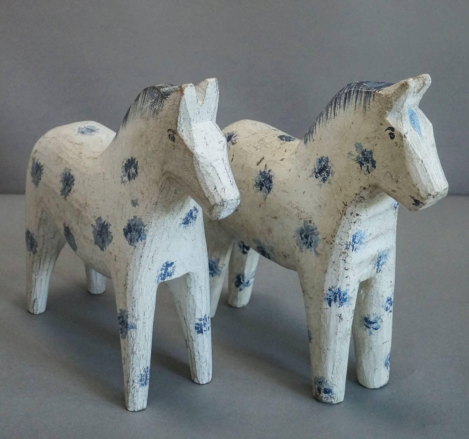 Carved Swedish Dalecarlian (Dala) horses, Sweden circa 1910, made as a child’s toy.  Original white paint and blue markings, separated ears, and feathered manes.  Charming example of flat-carving technique.