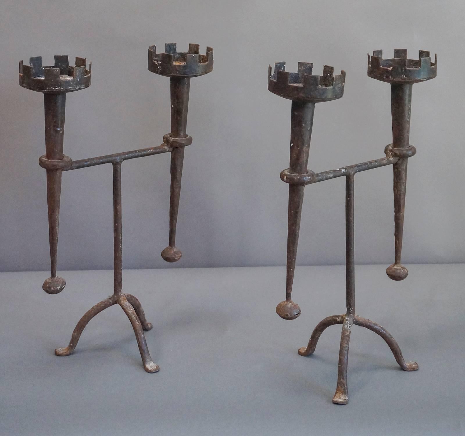 Pair of iron candleholders in the Renaissance revival style, Denmark circa 1910.  Each have a tripod base and holding two tapering torches.