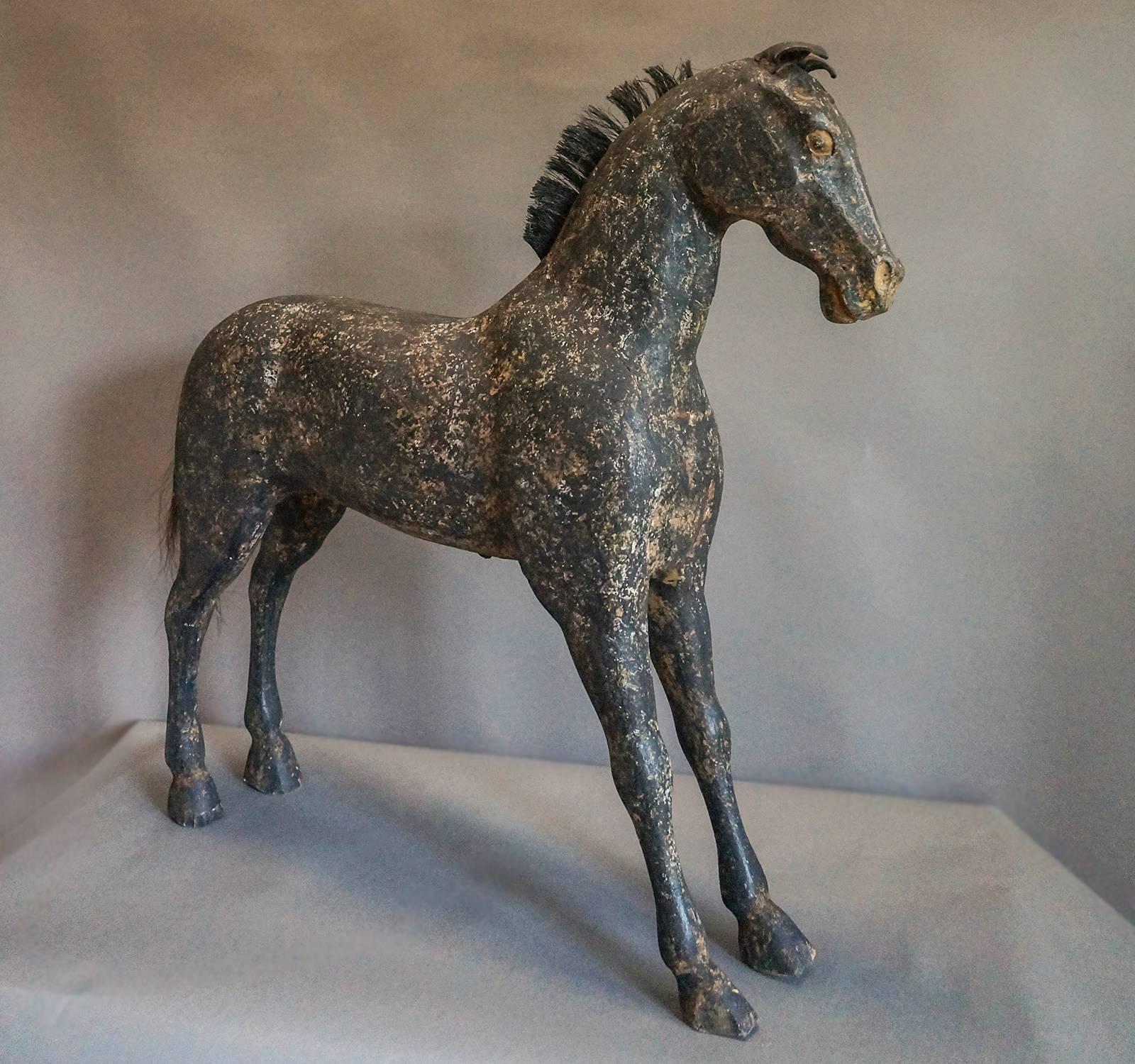 Large toy horse, Sweden, circa 1860, with original painted surface. Black horse hair mane and tail and leather ears. Fine carving of the head and musculature.