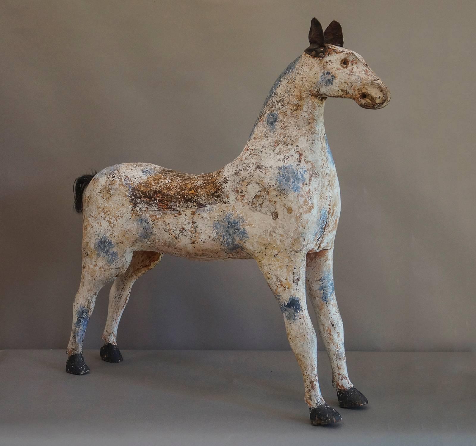 Toy horse in original paint, Sweden, circa 1860, with leather ears and horse hair tail. Charming blue spots and unusually a painted saddle blanket. Wonderful quizzical expression.
