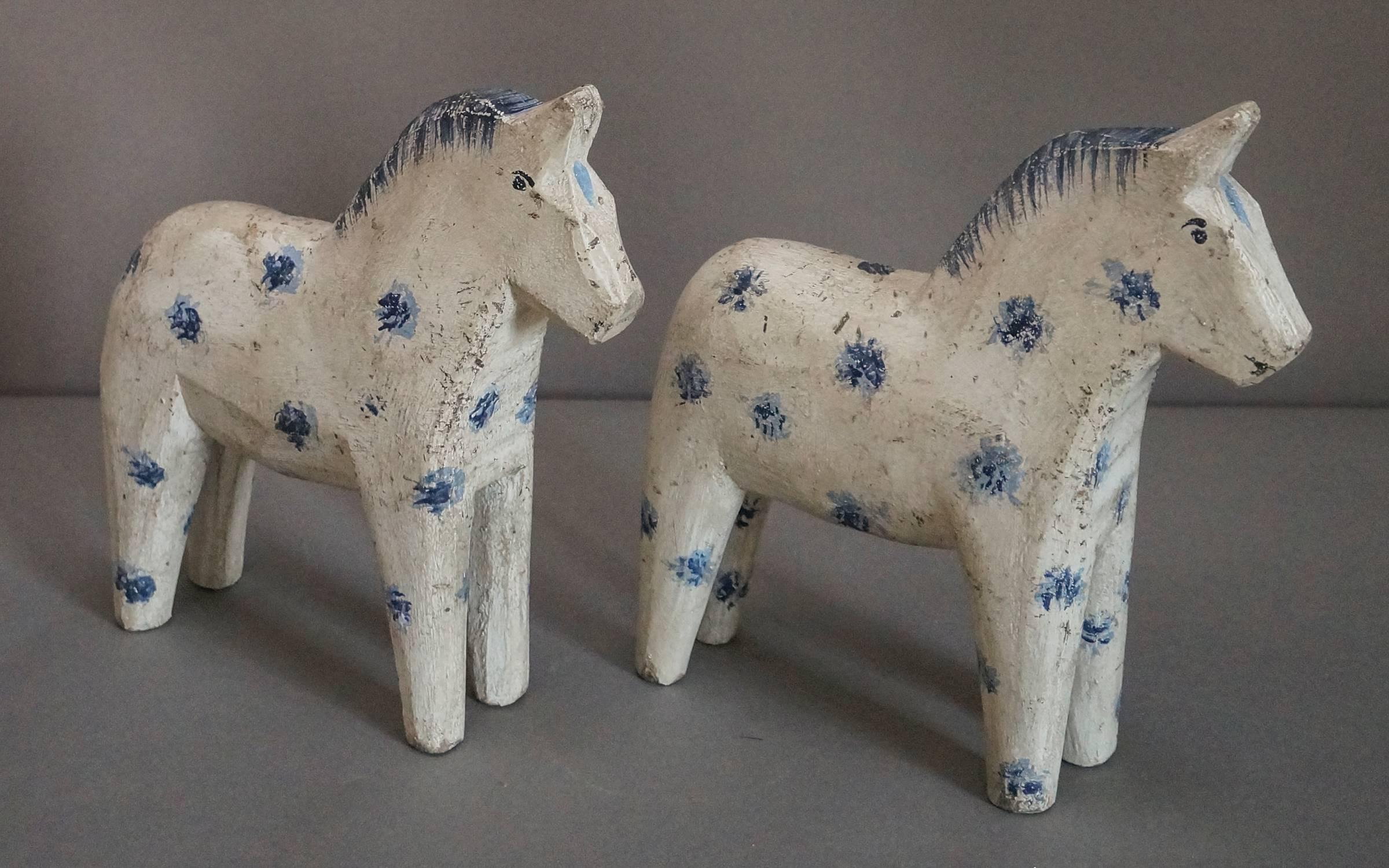 Pair of Dalecarlian (Dala) horses, Sweden circa 1910, in original white paint. Separated ears, and feathered manes.