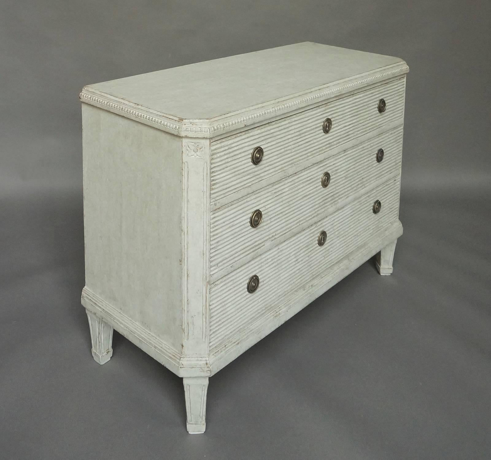 Chest of drawers in the Gustavian Style, Sweden, circa 1840. Dentil molding at the top, canted corners with carved floral detail and reeded drawer fronts. Original brass hardware.