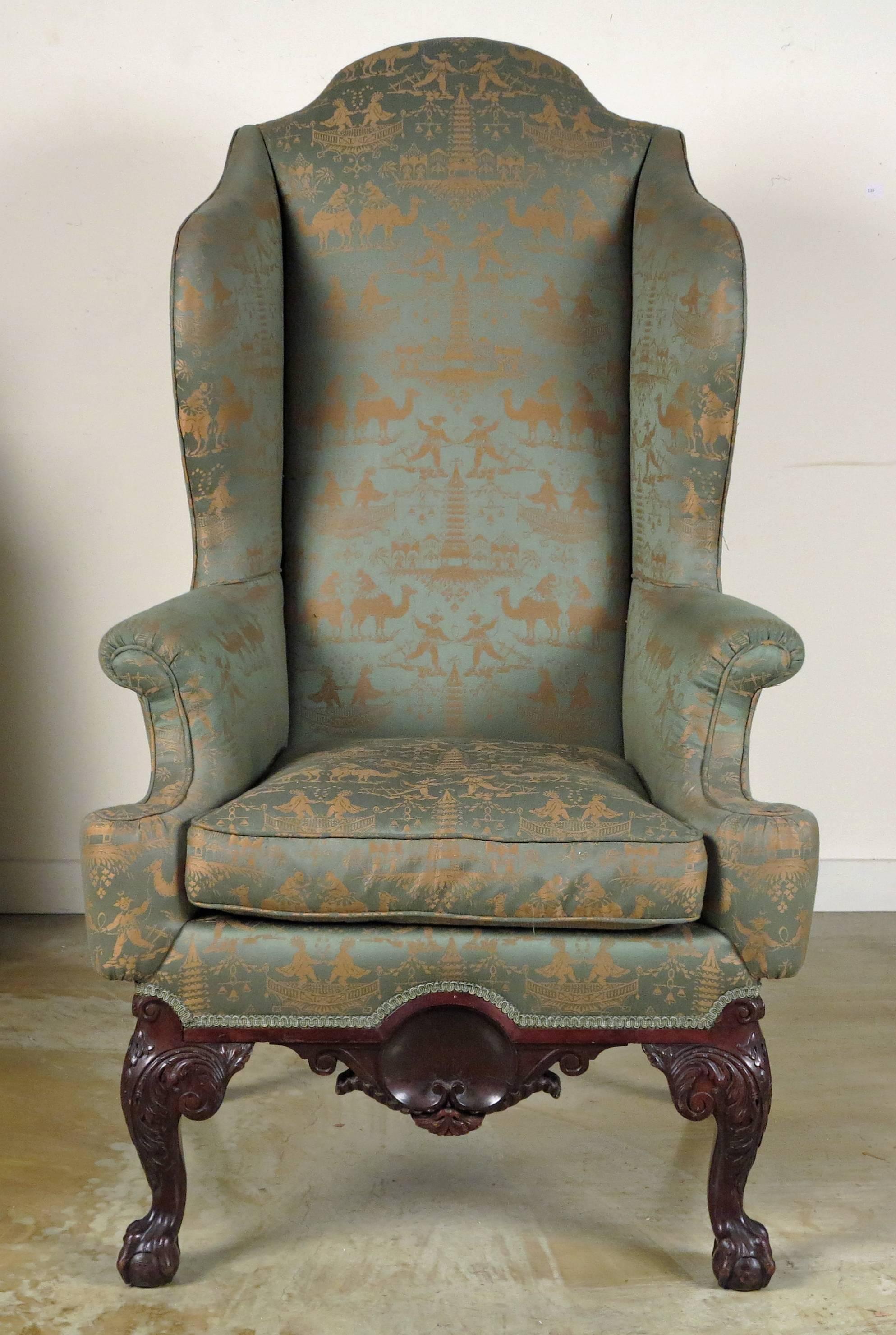 An unusual Chippendale style mahogany. 
Wingback chair possibly Philadelphia,
19th century.

The shaped back with shaped arms upholstered over a carved frieze with a shell motif all resting on carved cabriole legs ending in ball and claw