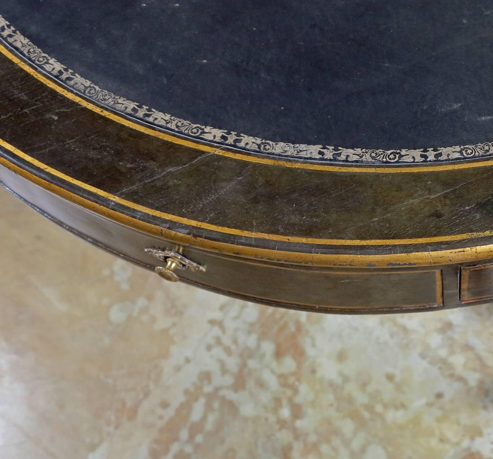 A Rare & Unusual Regency 
Baltic Circular Rent Table
Early 19th Century

The ebonized and parcel gilt table with a circular top with a tooled leather top over four drawers and four false drawers all resting on a tripod base with a central column