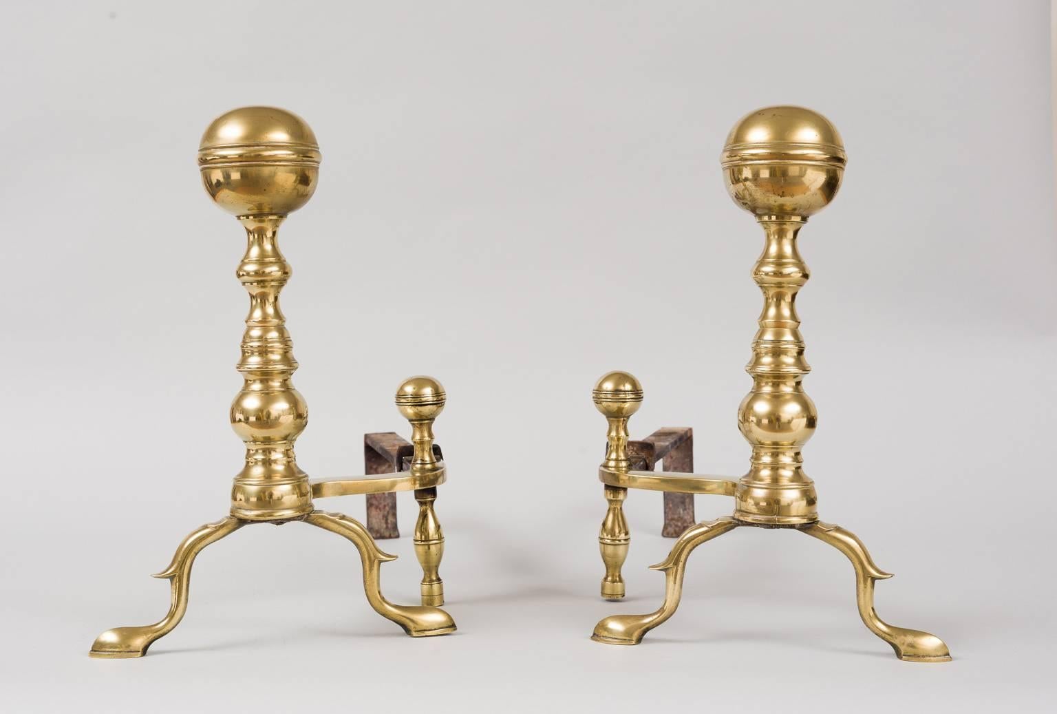 Pair of brass and iron ball topped andirons with matched and scaled curved log supports and stops raised on slipper feet, Boston. 

Item #7470.

     