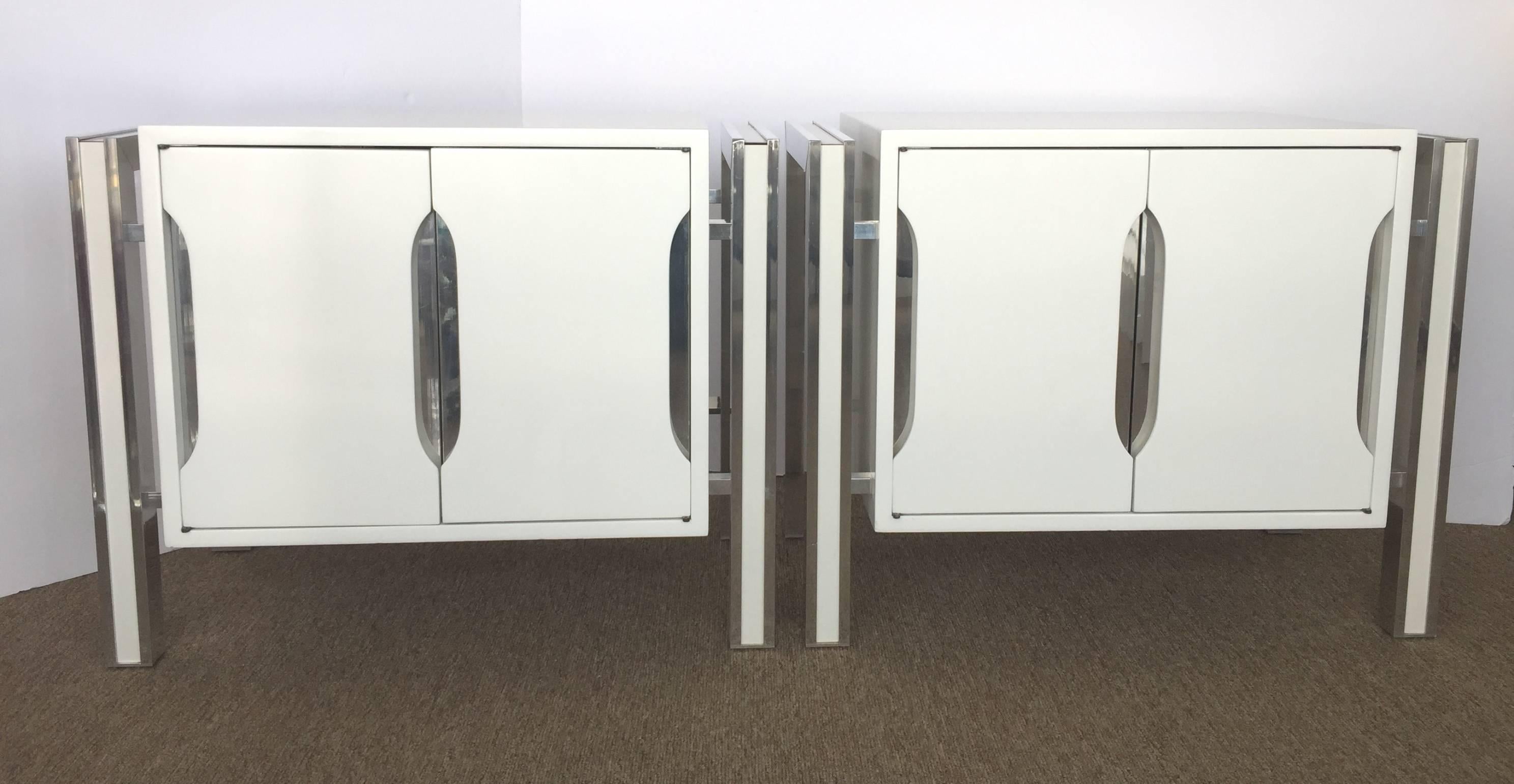 Great Mod end tables strongly anchor a room. Sculpted front doors white and insert chrome open to reveal an open cabinet with movable shelf. Legs are in aluminum frame detail on each side insert white satin laminate. Newly white lacquered, those
