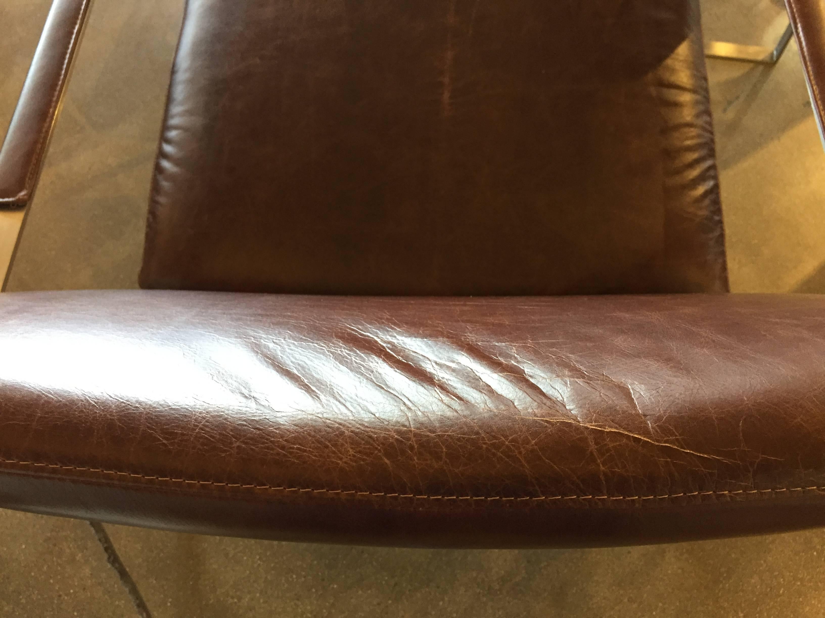 A quite lovely pair of brushed steel and ditstressed leather armchairs with overstitching detail. We have had these completely redone in a distressed brown leather, to give them a warm look. The frames are brushed steel and have allen head screws