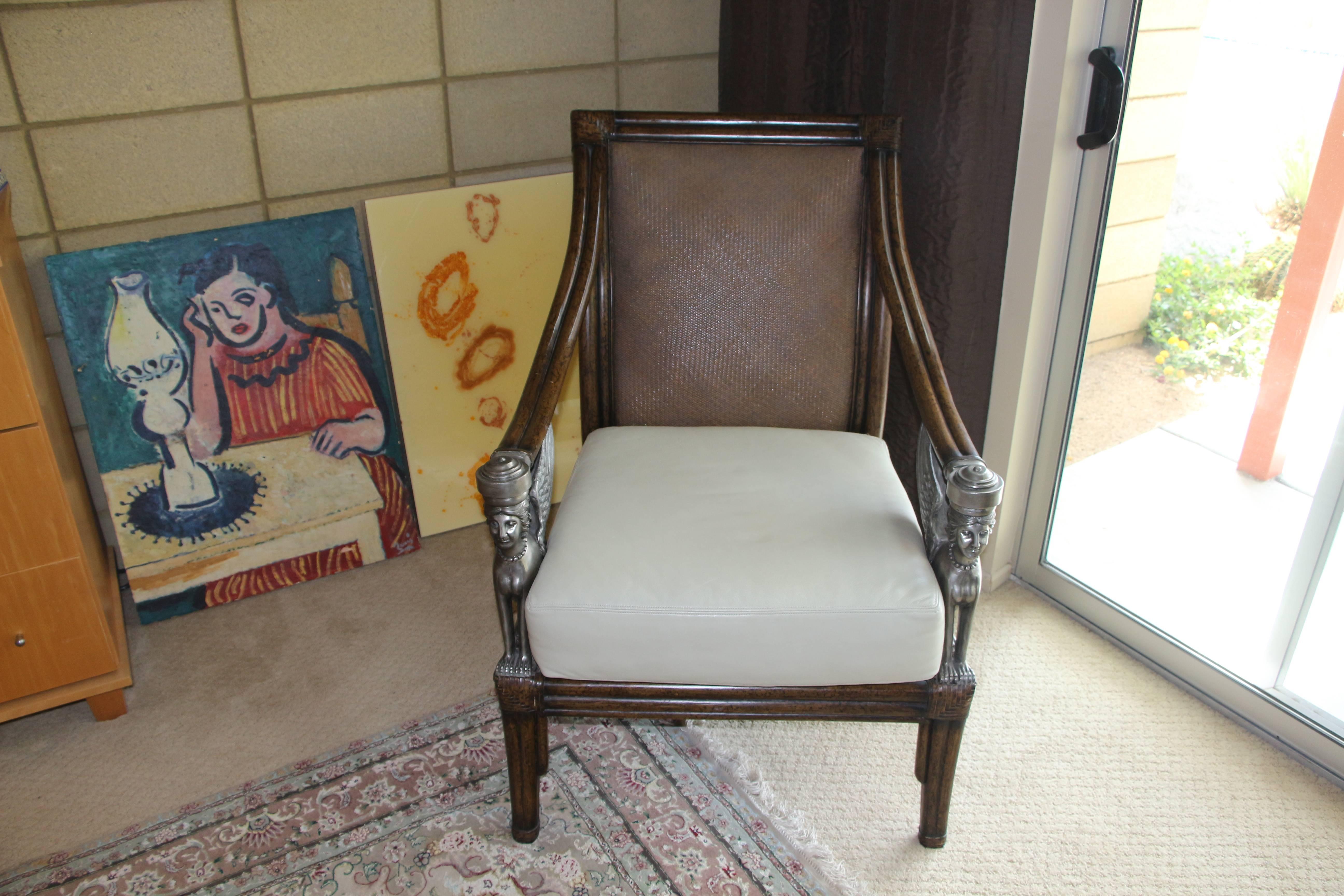 A wonderful armchair with a leather cushion seat that appears to have been recently re-upholstered. The chair made or wood, rattan and fantastic metal Sphinxes as arm supports. This estate was filed almost exclusively with Maitland-Smith or Marge