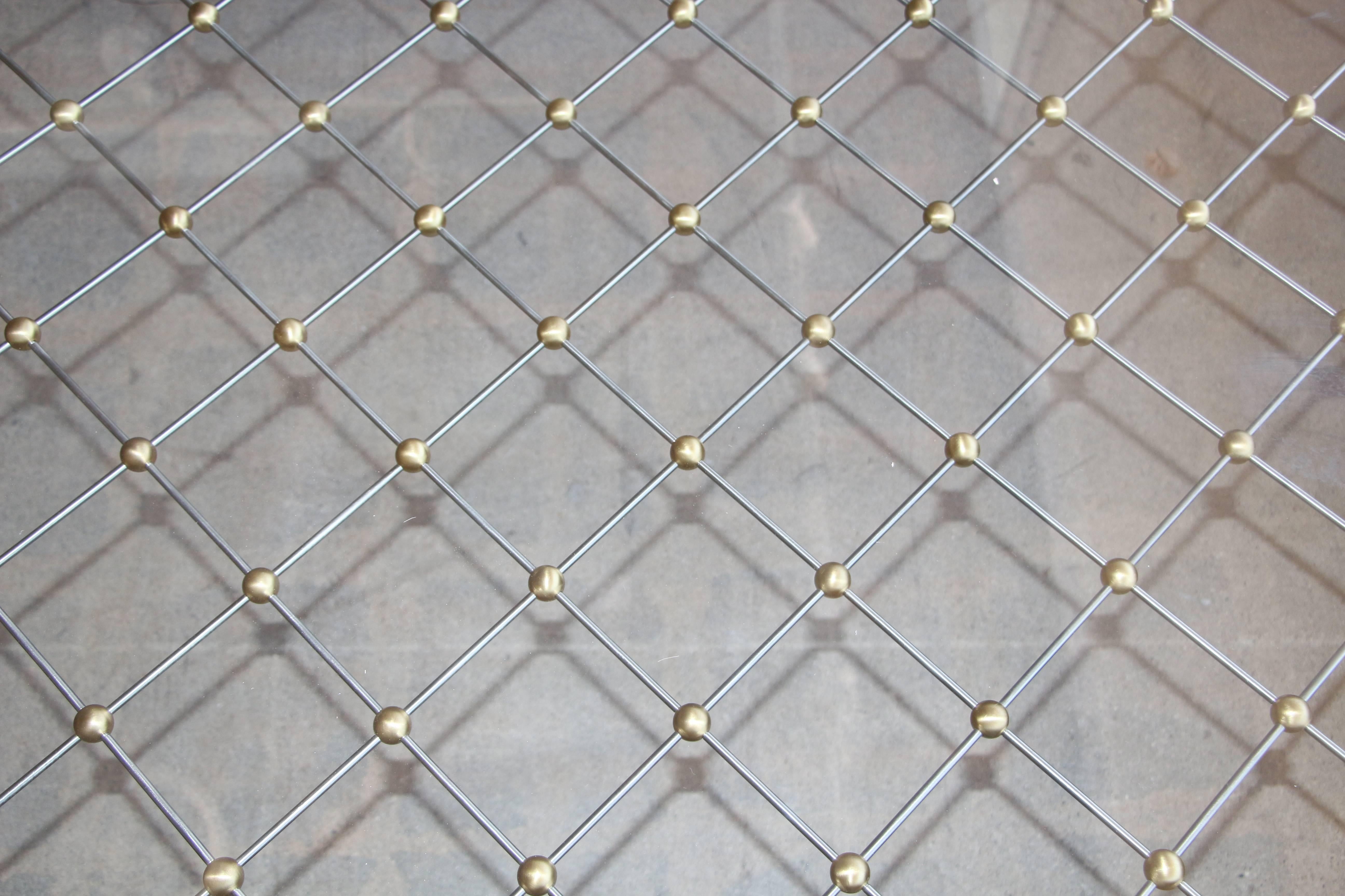 A custom-made coffee table after Jean Royere's Classic Tour Eiffel coffee table. This table was ordered and bought by the estate we purchased it from in a custom wider size than the original. It is also made with a bronze frame as opposed to the