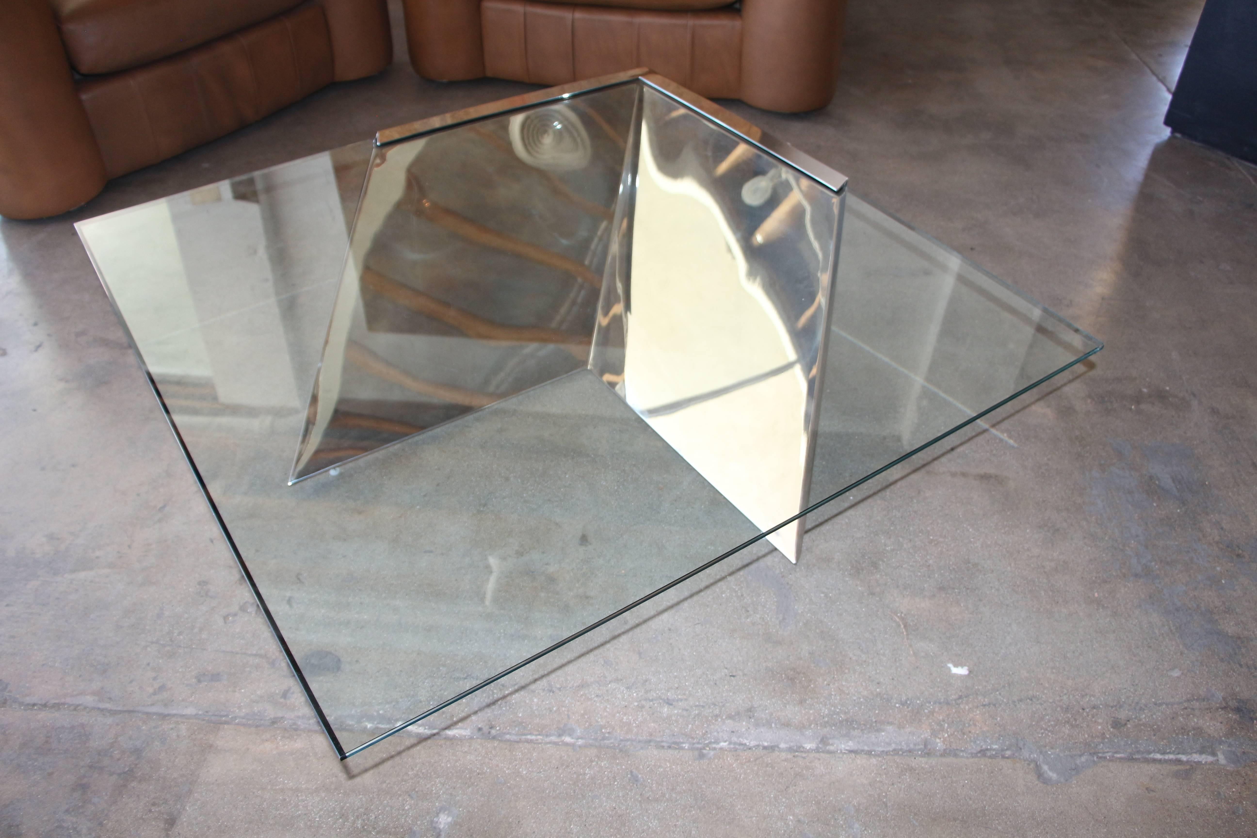 A beautiful polished steel and glass cantilevered coffee table named the SMT. The initials stands for so much trouble, as this is a difficult table to create. This is the correct size and correct glass size built by the manufacture. The glass