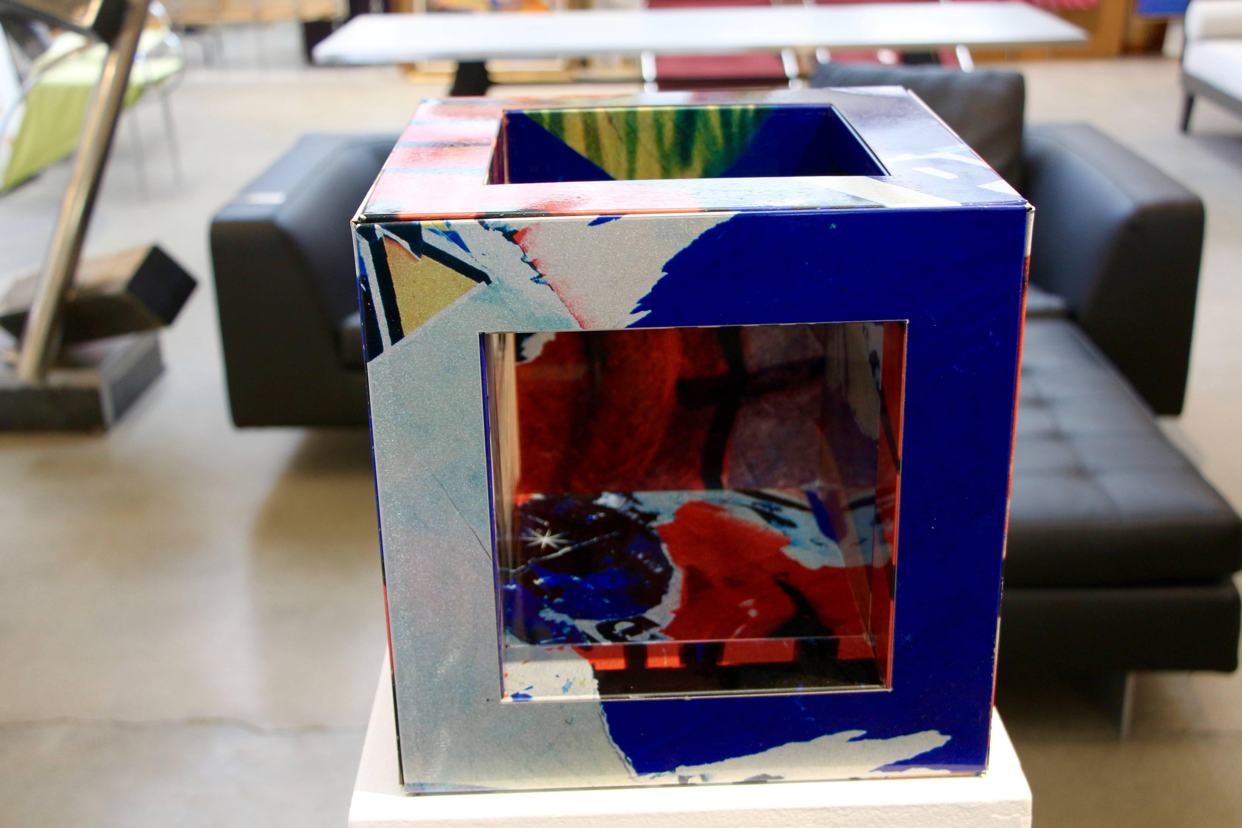 This rare and unique cube is from an edition of only four pieces. We have seen cabinets and small tables but never this from. It is also finished on the base. Ir is a technique of decollage which is a lithograph transfer printed onto metal. This