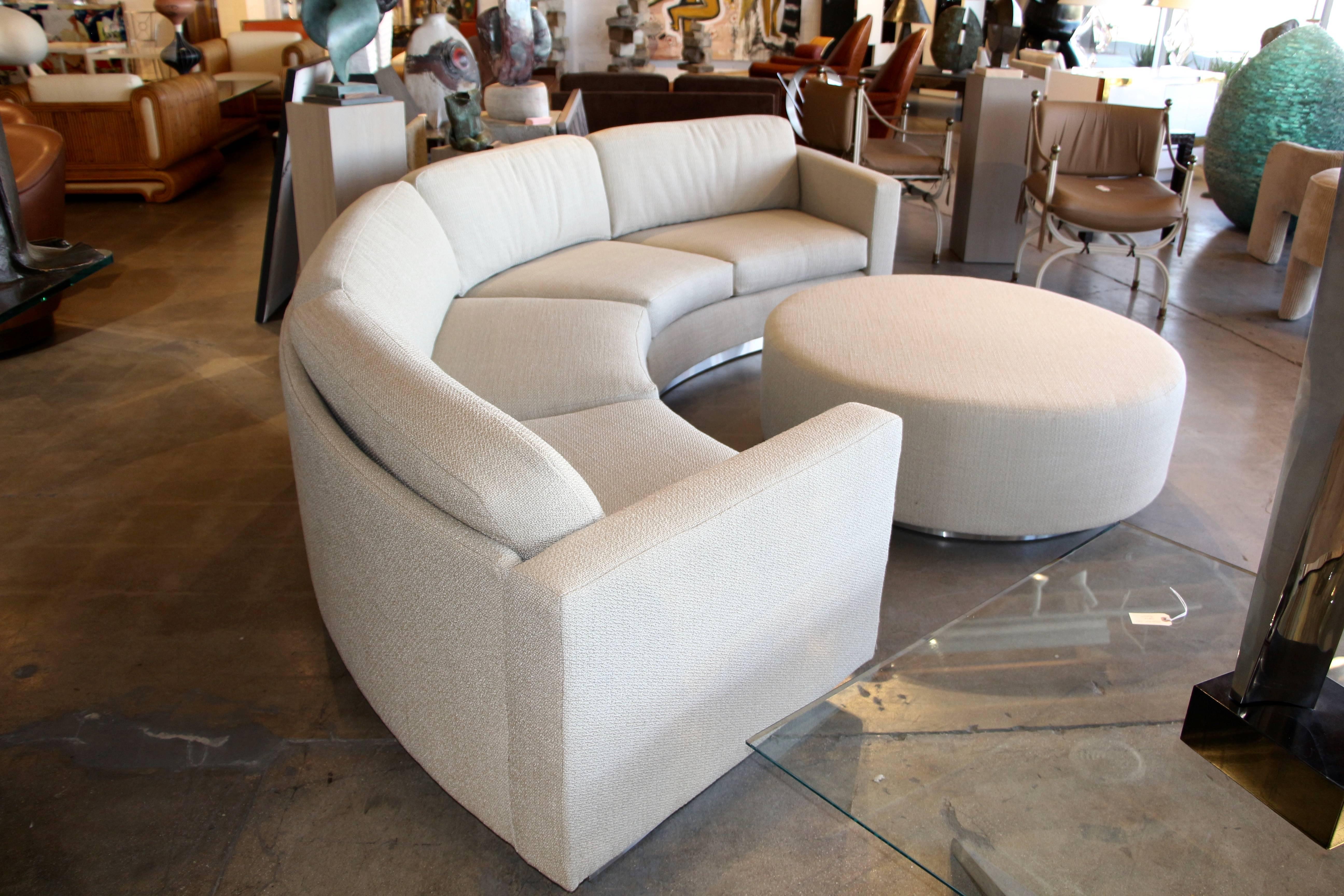 A great looking Thayer Coggin by Milo Baughman designed sectional curved sofa with matching ottoman. We have had the sofa and ottoman completely restored and re-upholstered. Additionally we have added a plinth base covered in brushed steel. This