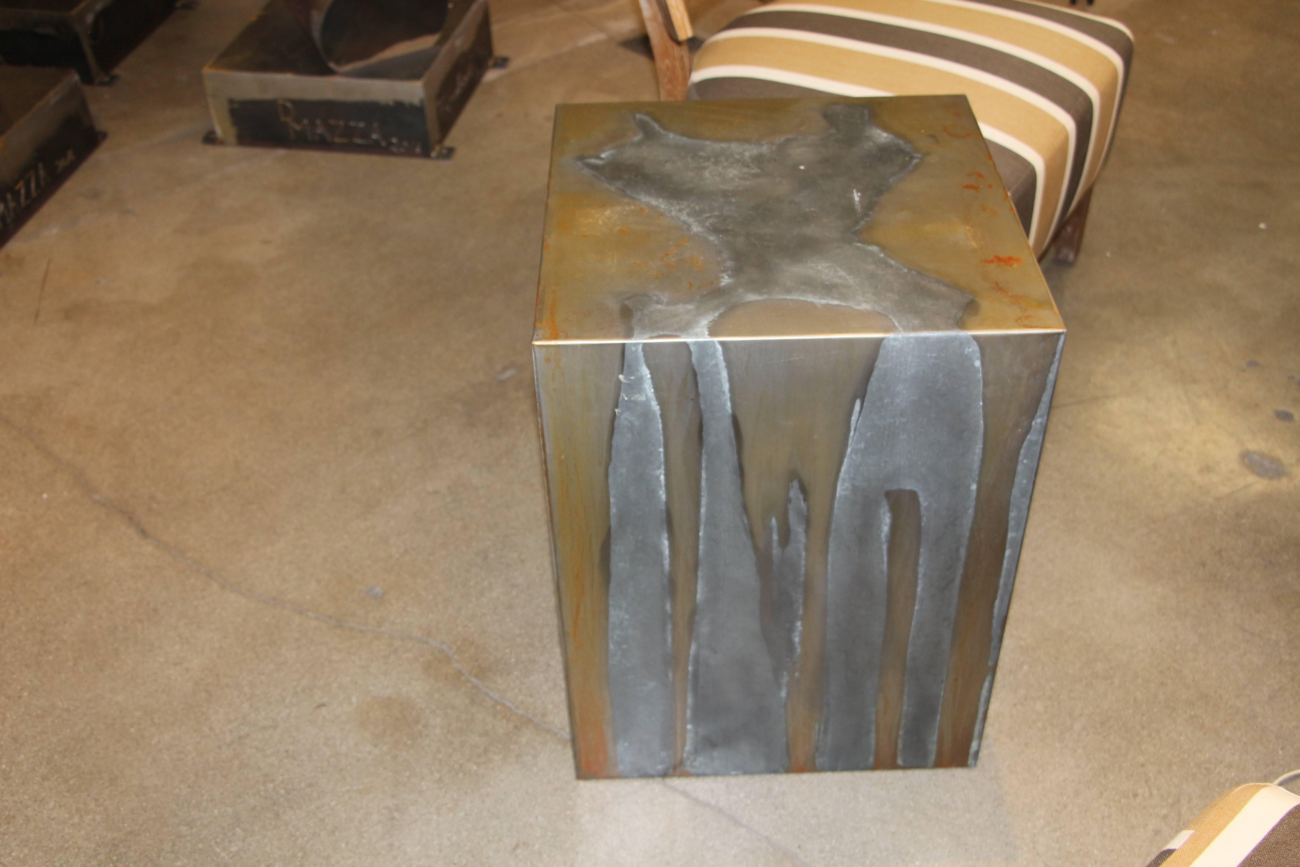 A very unusual cube table wrapped in zinc and brass coating. Very nice patina. There is some rusting to the top. It may be easy to remove with polishing but we have not tried. Some nicks and scratches as well.