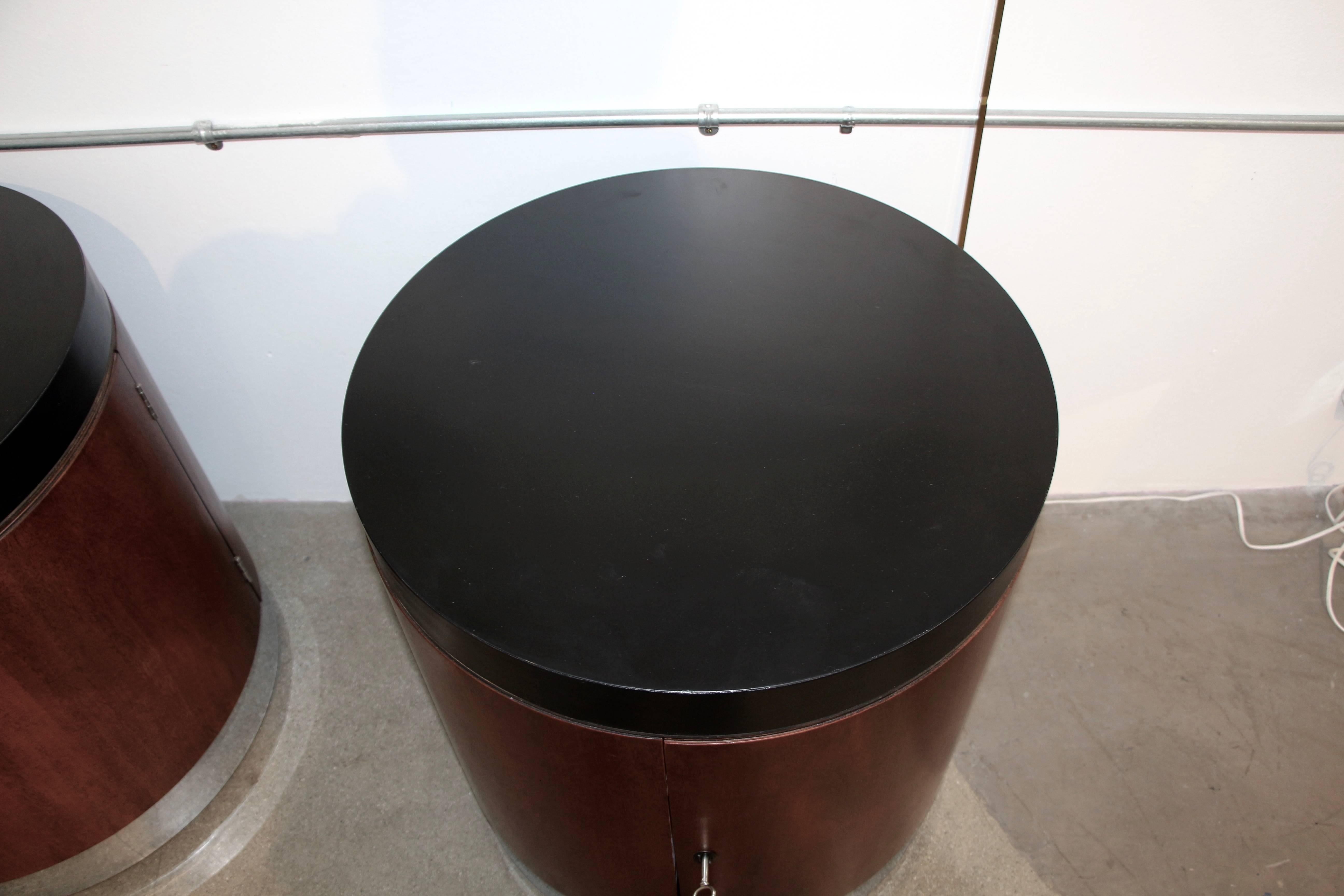 A nice pair of 1980s vintage Polo by Ralph Lauren end tables or nightstands. These circular tables are lockable and there is one key for both. They bear the Polo Ralph Lauren brass tag. Tops are painted black with nicely grained wood middles and