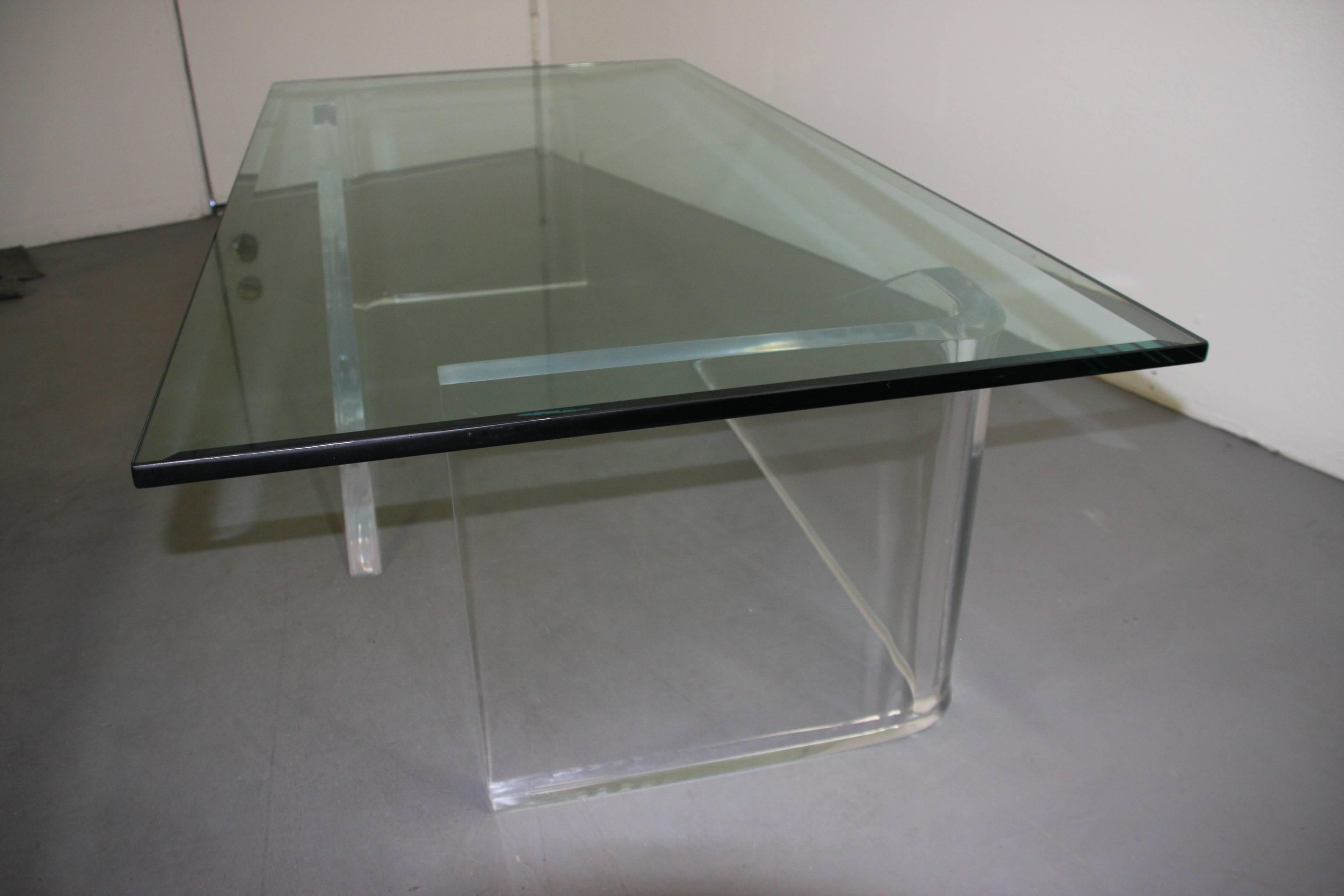 An interesting and unusual coffee table with a lucite base and nice glass top.
