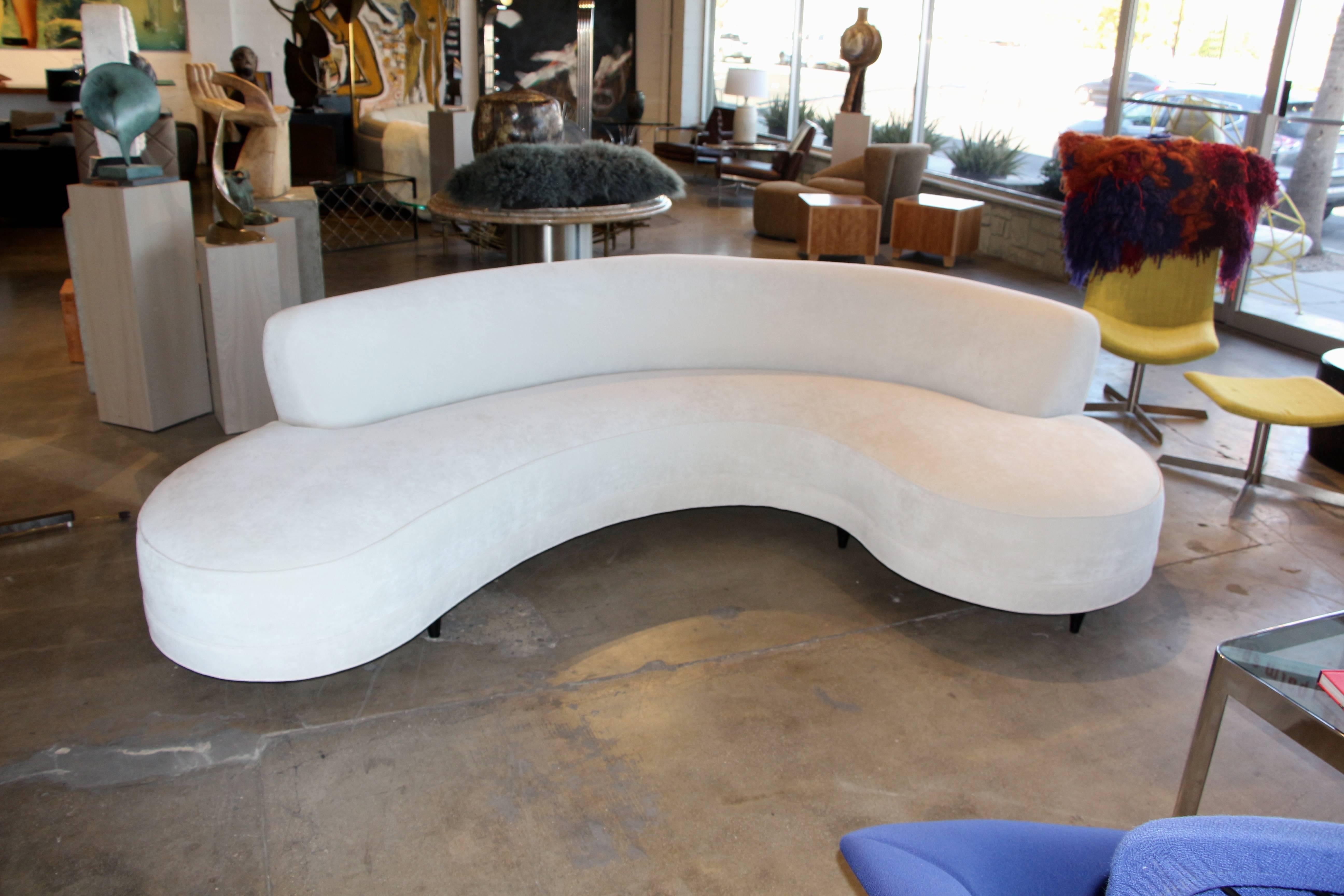 A beautiful Kagan Dreyfuss Serpentine sofa that was in an old time palm springs hotel. We have had it reupholstered and redone. It has a great circular shape. It sits on walnut legs that have been painted black. A very sexy sofa. the back has a