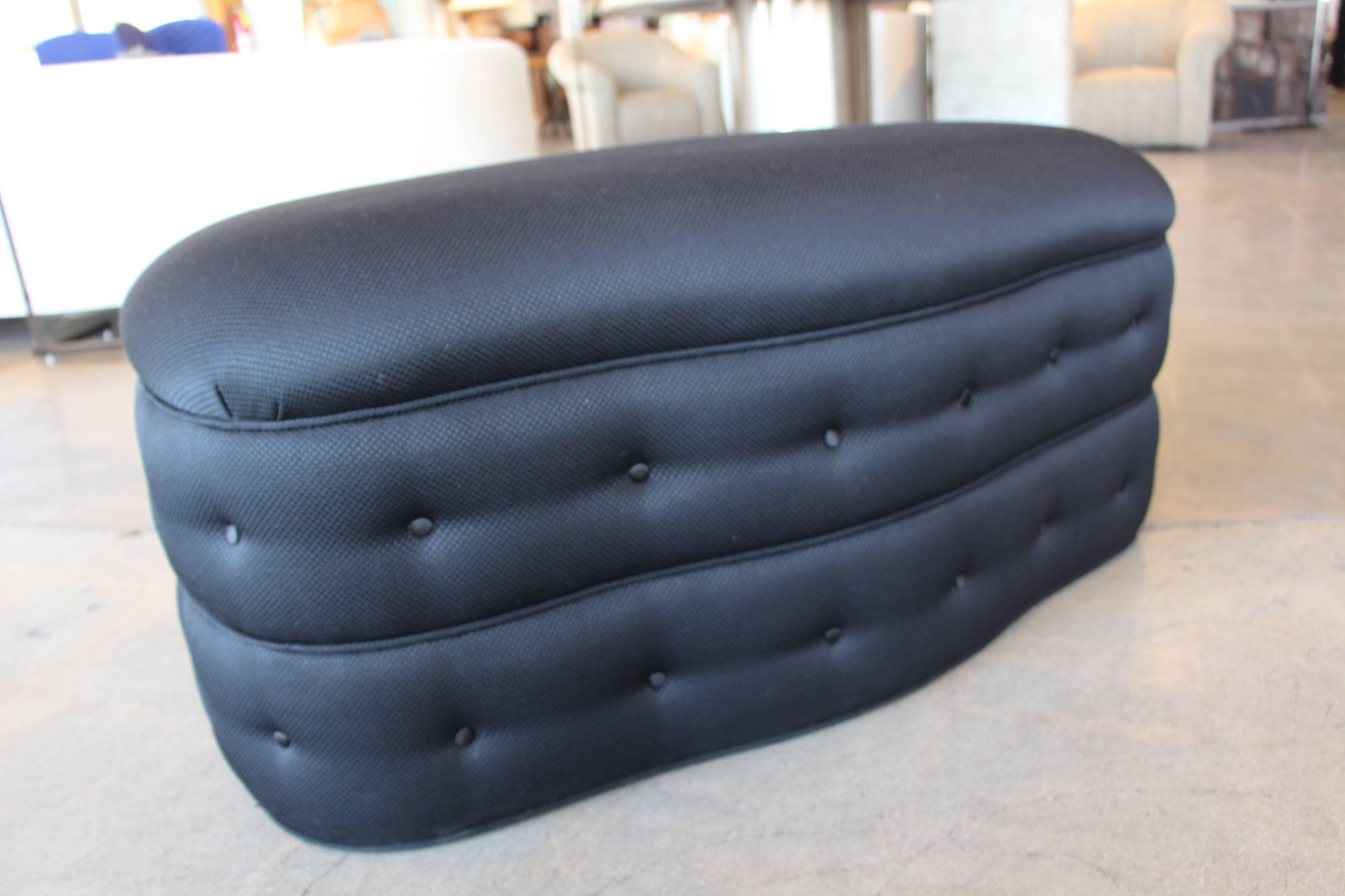 A nicely re-upholstered ottoman or pouf in a nice black fabric. It is on castors and moves easily.  Re-Upholstered in 2019 with some minor handling marks now. 