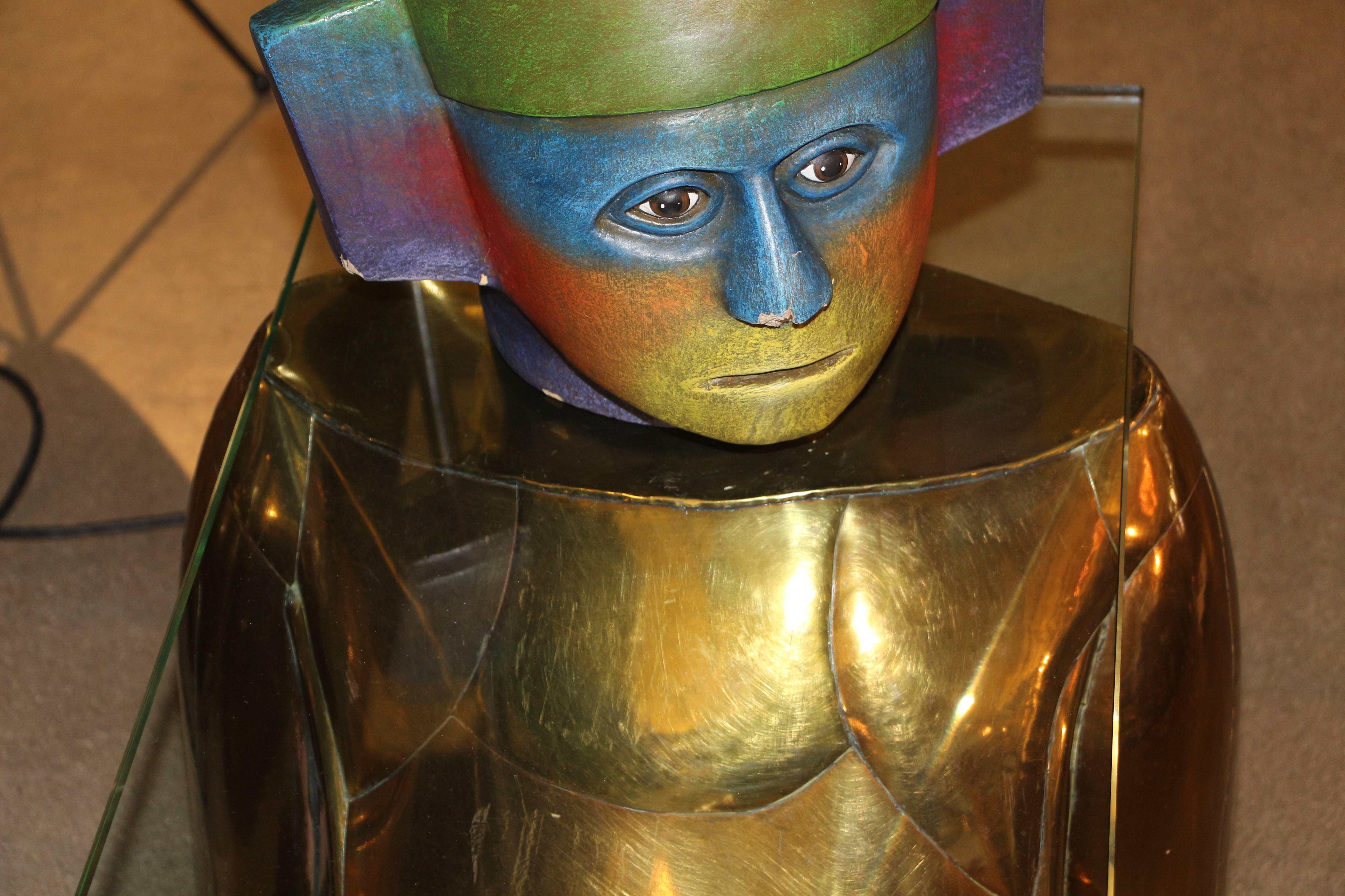 An unusual Mario Gonzales brass, copper and ceramic painted head table. The head rests on the glass. The head has damage to the nose area, but the table can be used without the head. The copper inset has glass eyes. It is signed.
Measures: Table is