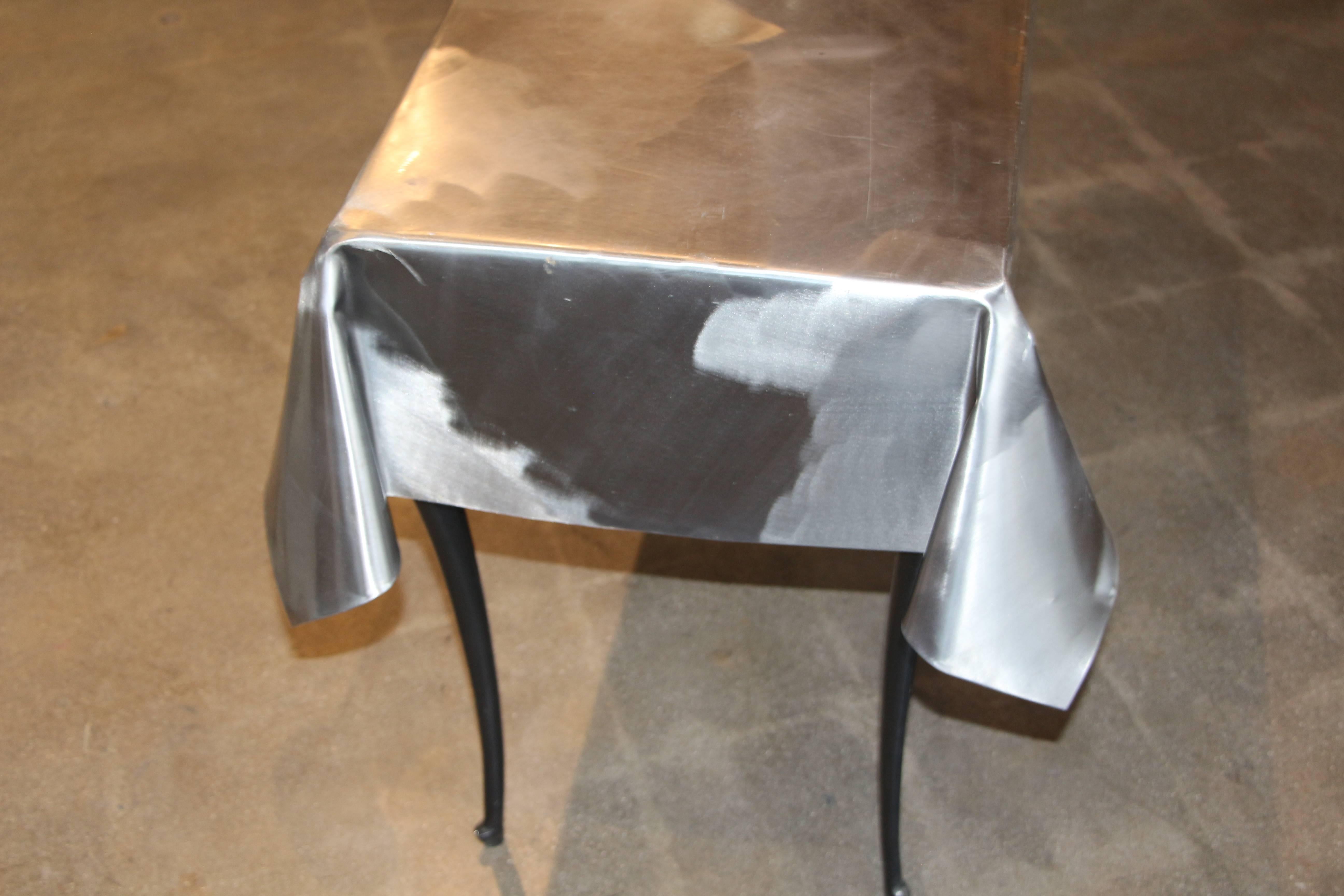 A most unusual metal draped console table with legs. A magnet sticks to the top so it may be some sort of steel. The magnet does not stick to the legs. Very nice finish to the tabletop. The base looks like this was not a production piece, more of a