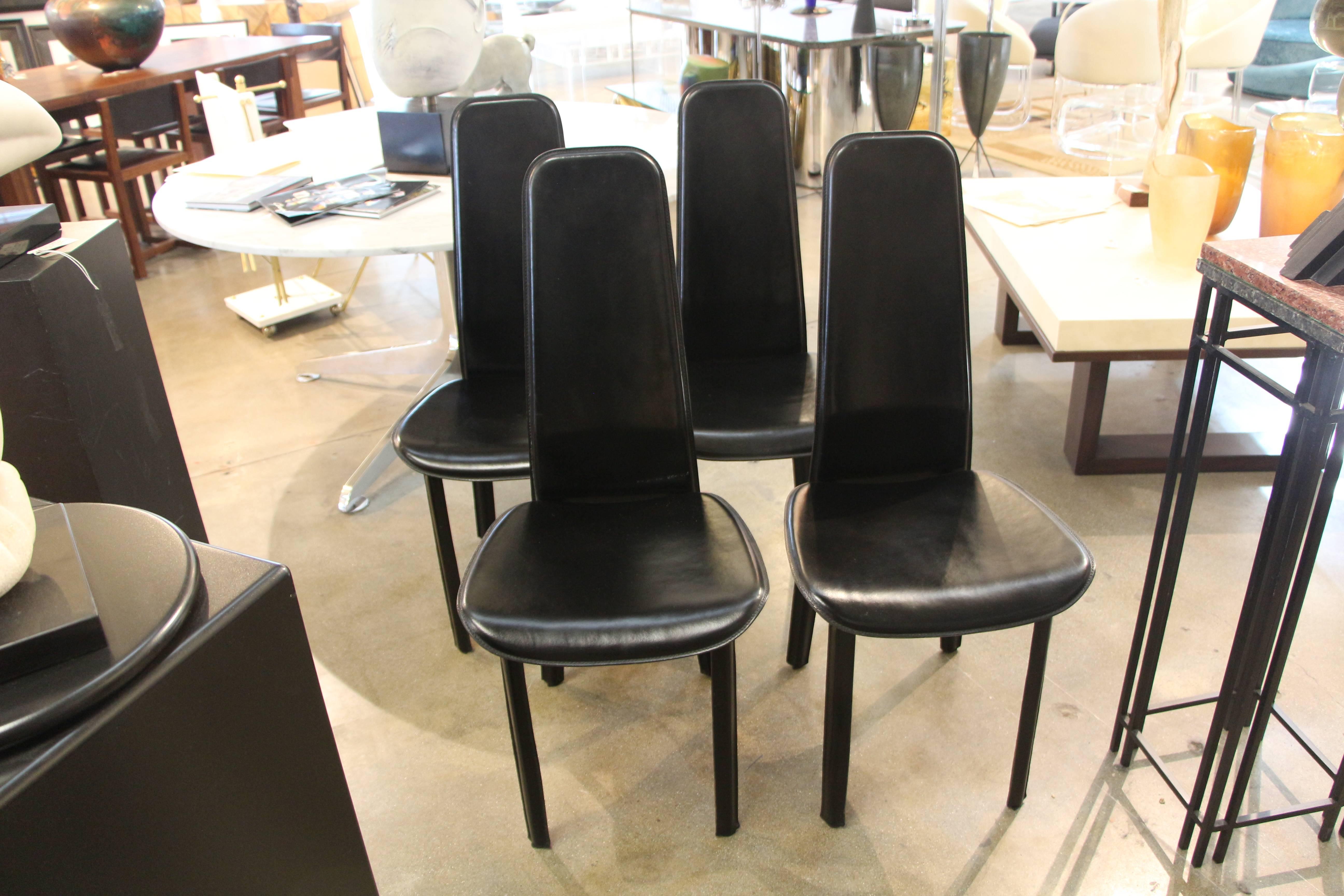 A set of four Cidue Italian black leather chairs. There are in good used condition, with age appropriate wear. There are marks nicks scratches and one chair has a small white paint spot, pictured.